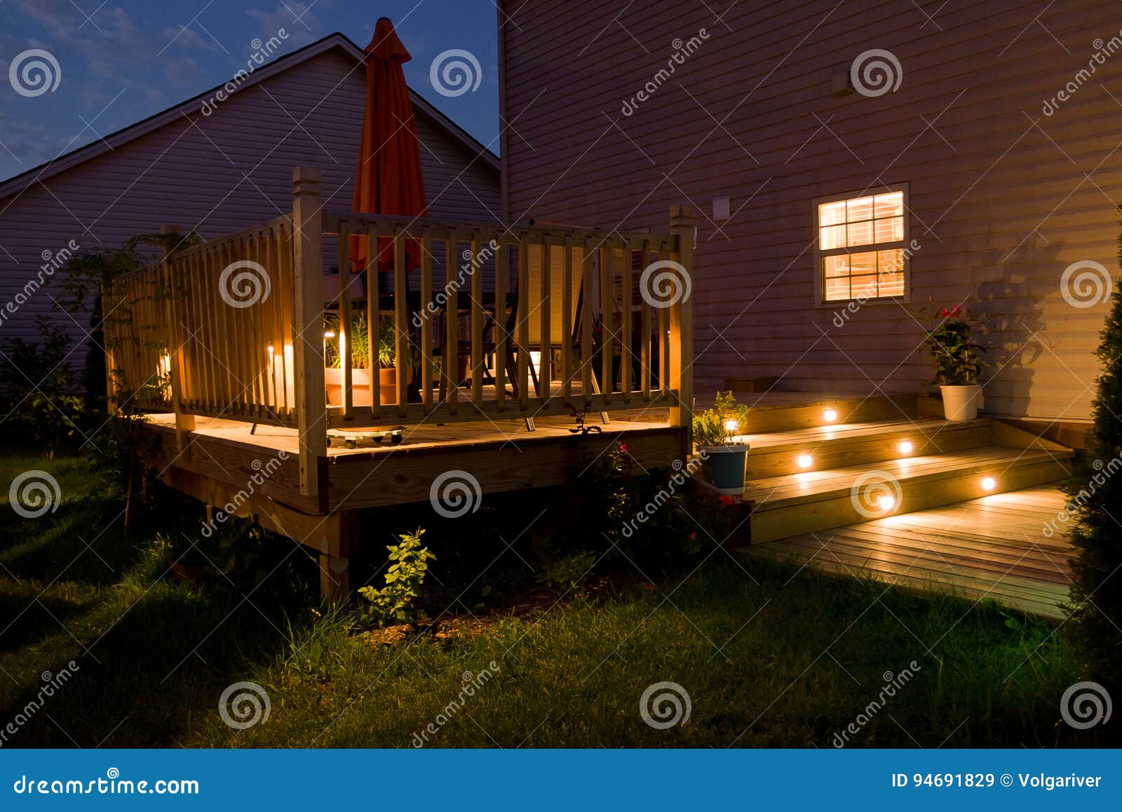 wooden deck and patio of family home at night.