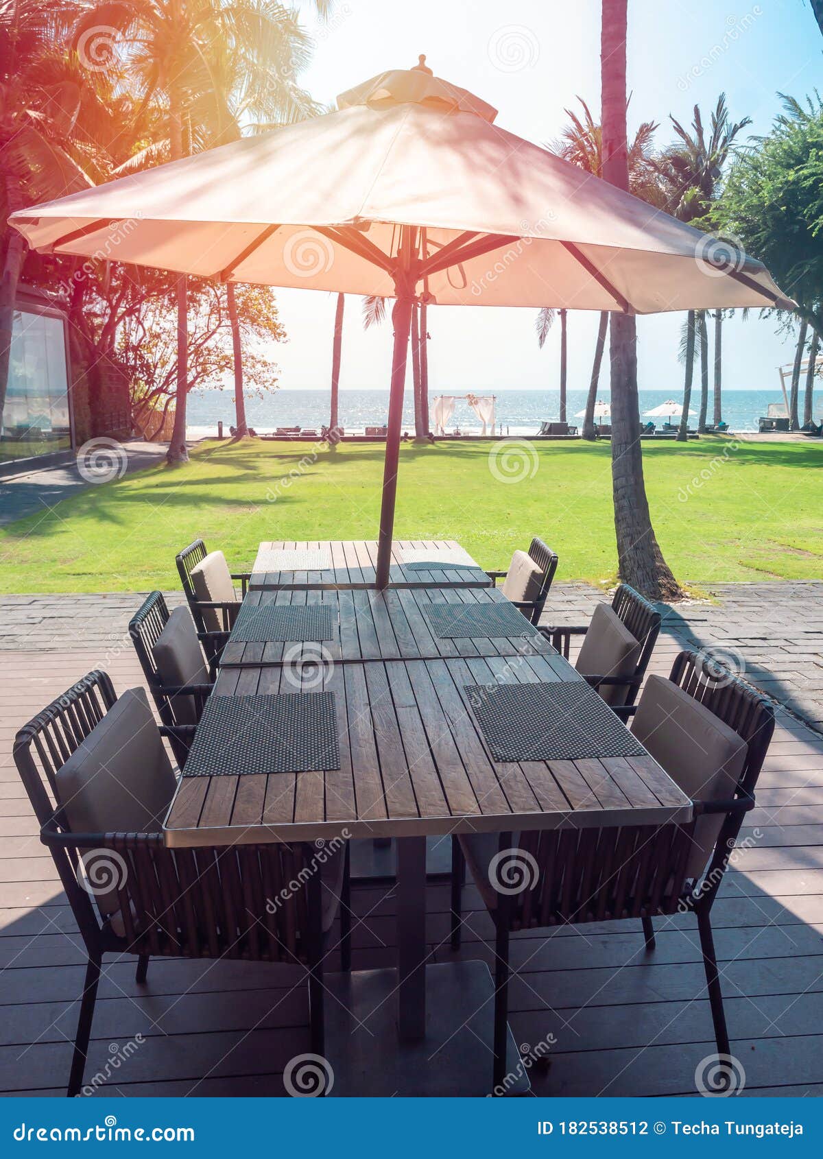 Wooden Dining Table And Chairs With Beach Umbrella With Sea View Stock Photo Image Of Chairs Breakfast 182538512