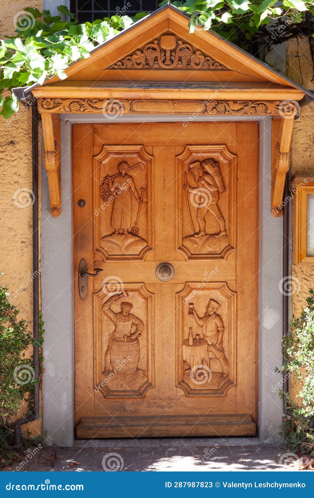 wooden door with carvings of people depicting winemakers