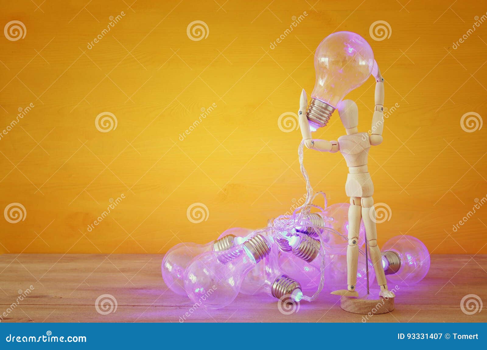 Wooden Dummy Holding Shiny Light Bulb. New Idea Concept Stock Image