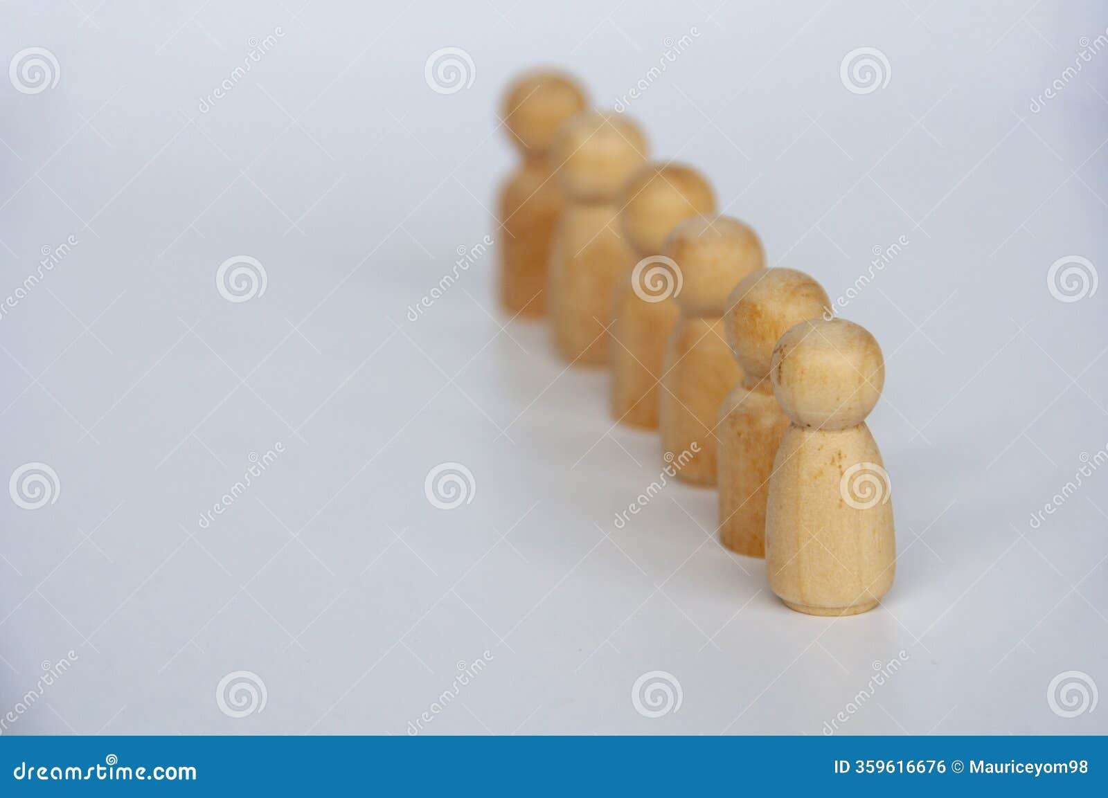 a wooden figure leading other wooden figures with customizable space for text. leadership concept.