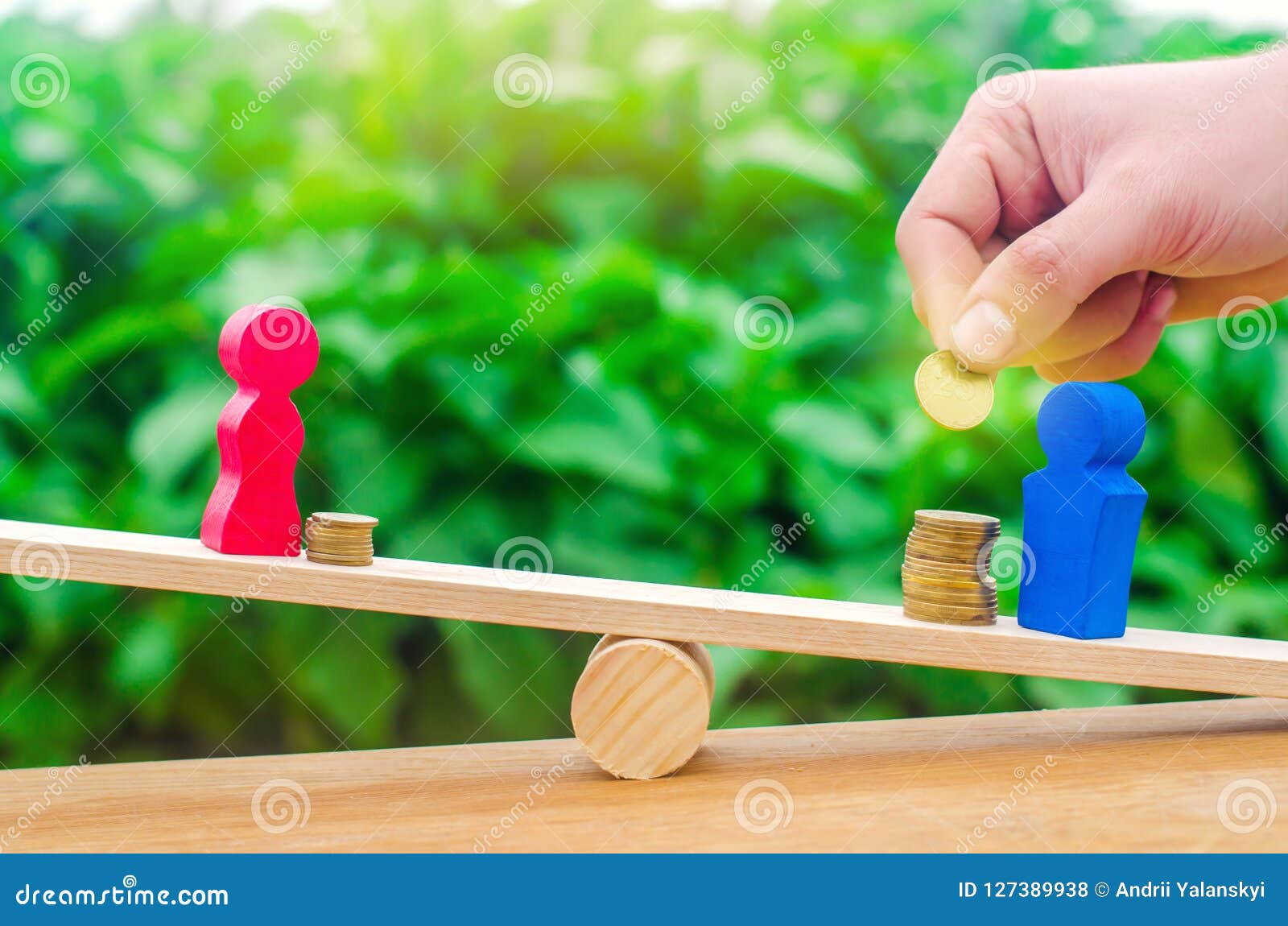 wooden figures of a man and a woman stand on the scales and coins between them. concept of the gender pay gap. income inequality.