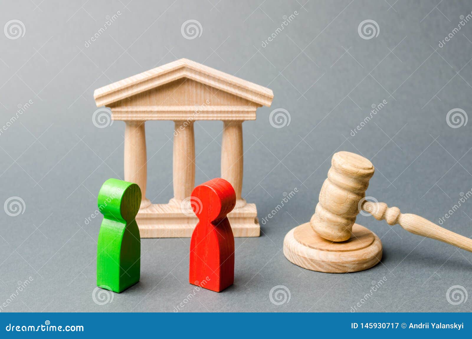 wooden figures of people standing near the judge`s gavel. litigation. business rivals. conflict of interest. law and justice. the