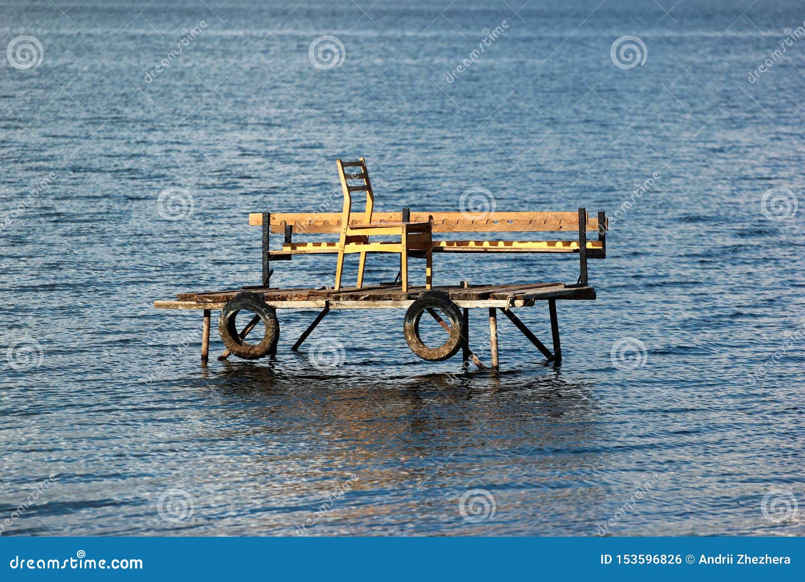 Wooden Fishing Platform in Water, with Tire Fenders and Chair