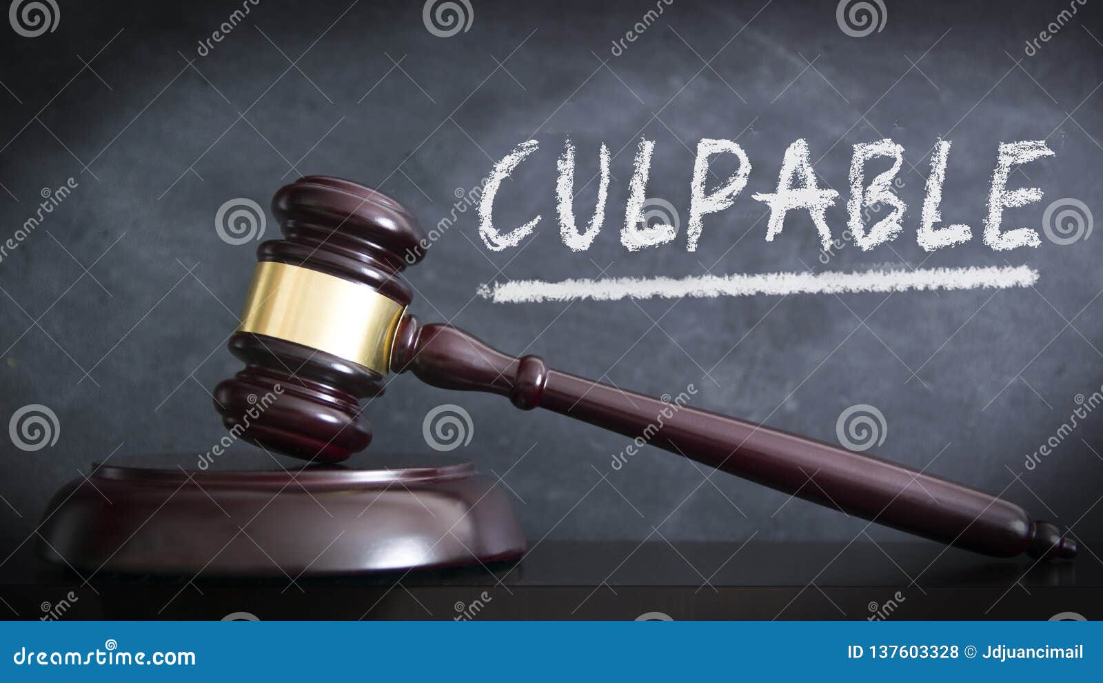 wooden hammer in a courthouse at verdict of guilty in spanish `culpable` in a judgement. hand written concept