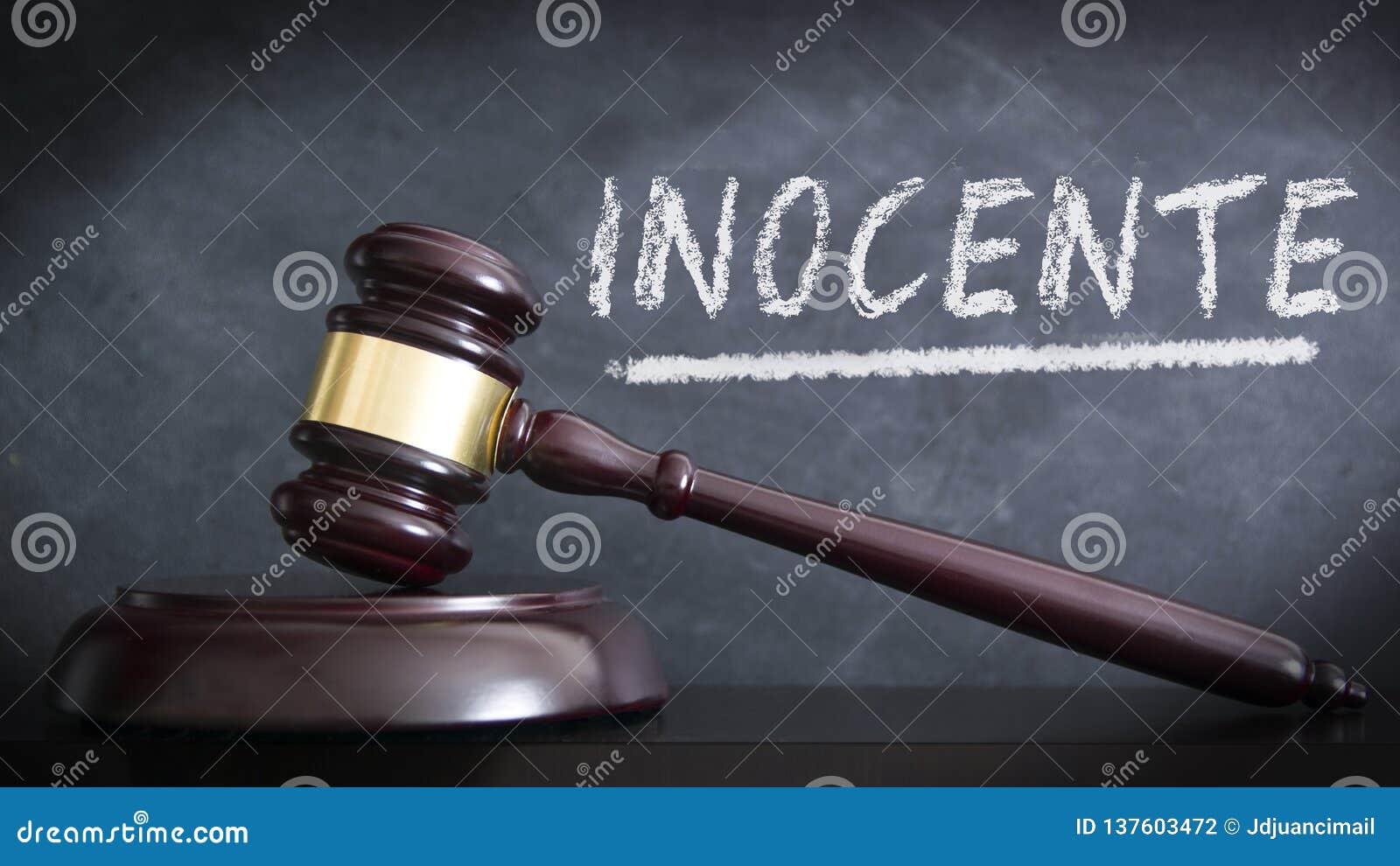 wooden hammer in a courthouse at verdict of innocent in spanish `inocente` in a judgement. hand written concept with chalk