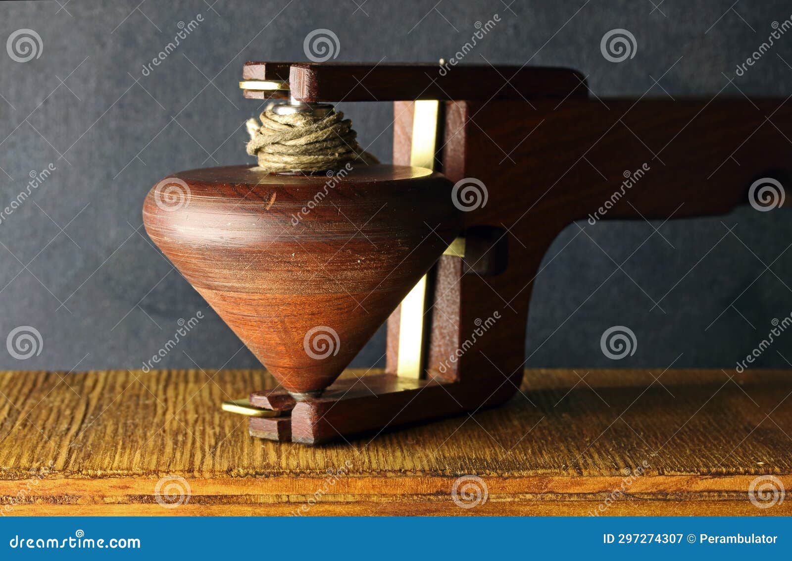 WOODEN HANDCRAFTED SPINNING TOP POSED in a LAUNCHER Stock Image Image