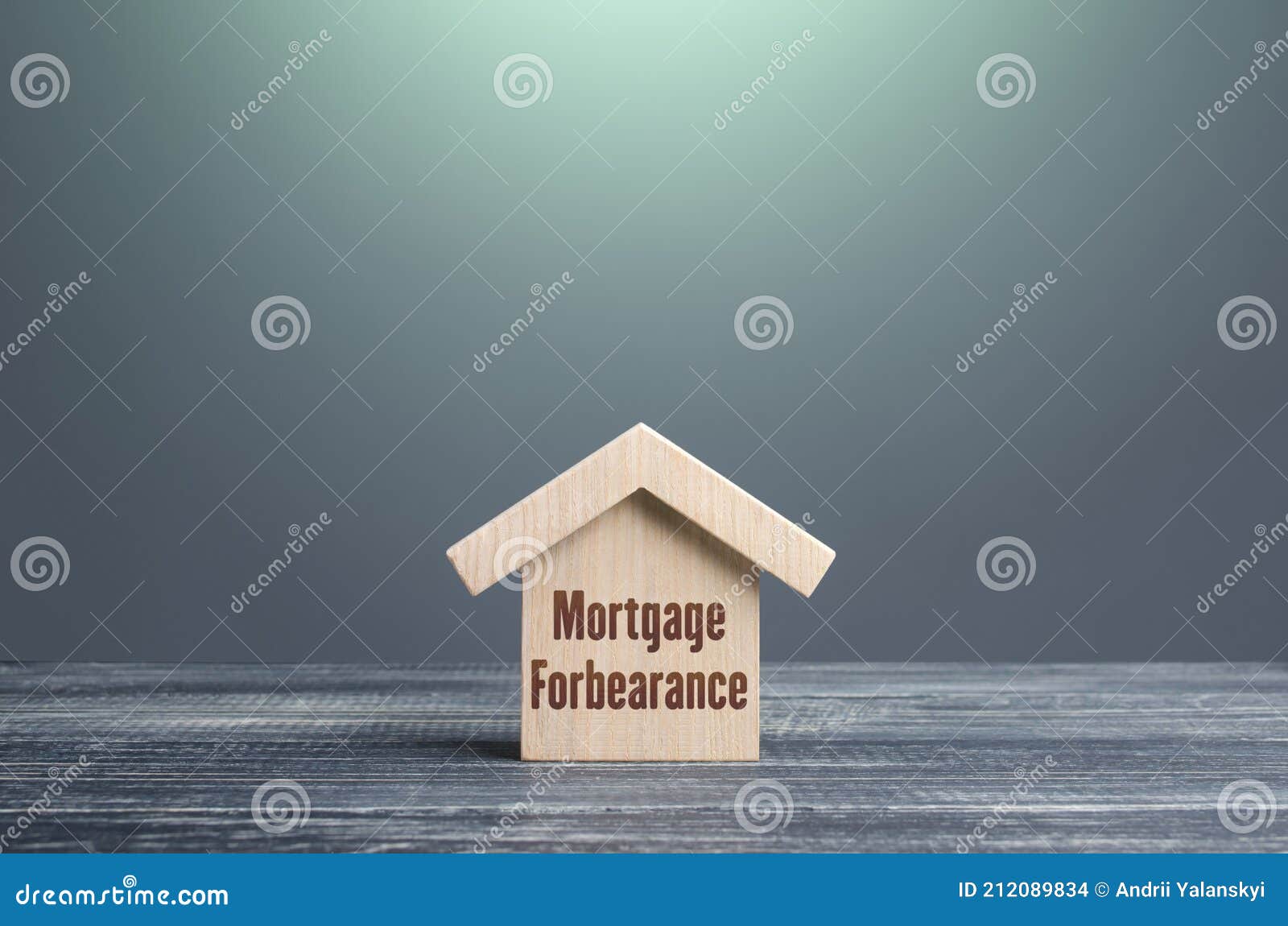wooden house figurine with inscription mortgage forbearance. borrower and lender agreements reduce or suspend mortgage loan