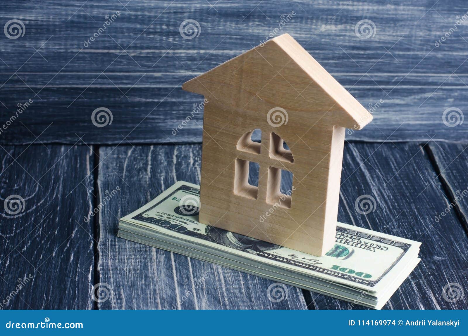 a wooden house stands on a stack of dolor banknotes. the concept of buying and selling immovability, rent of apartments.
