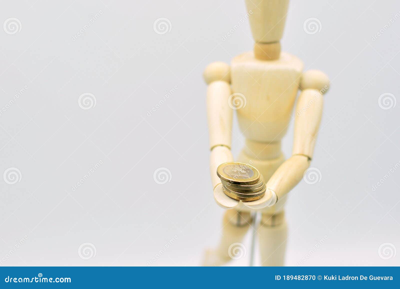 wooden mannequin with coins