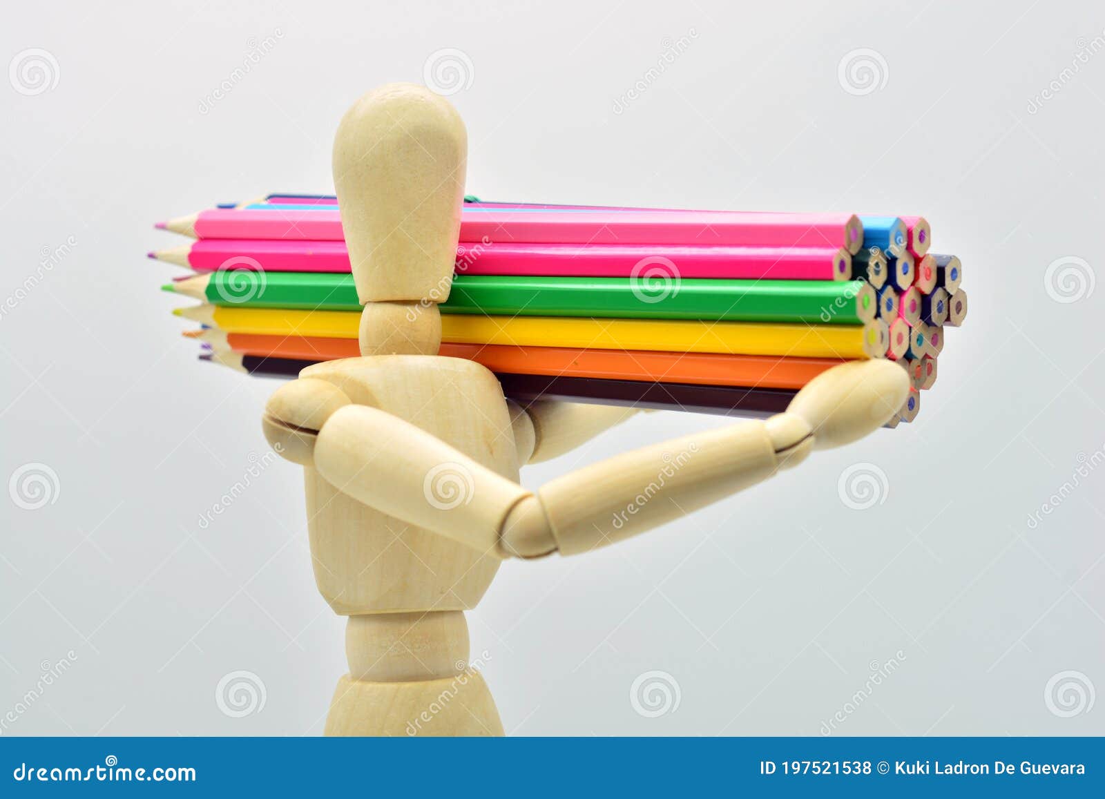 wooden mannequin loaded with colored pencils