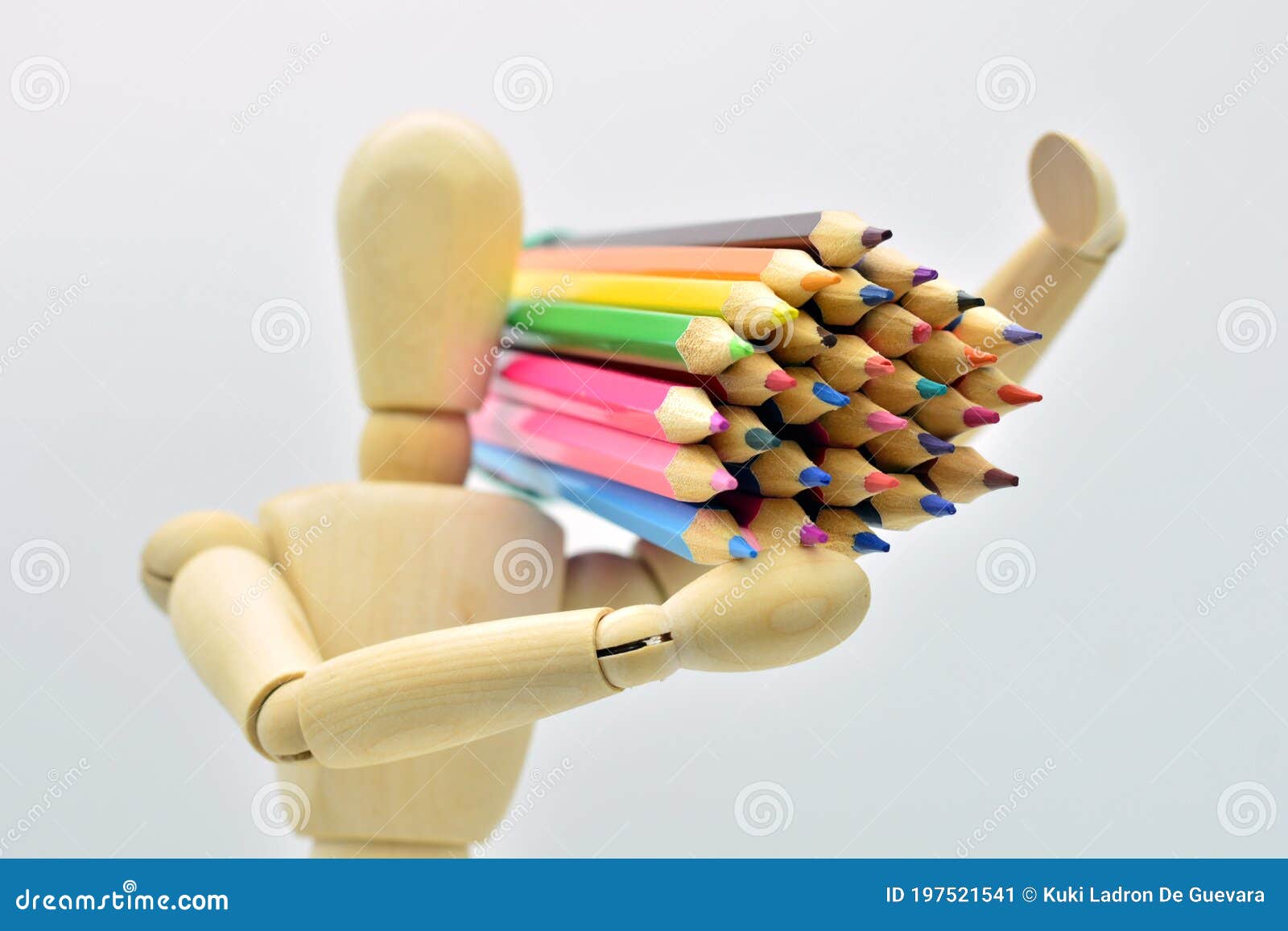 wooden mannequin loaded with colored pencils