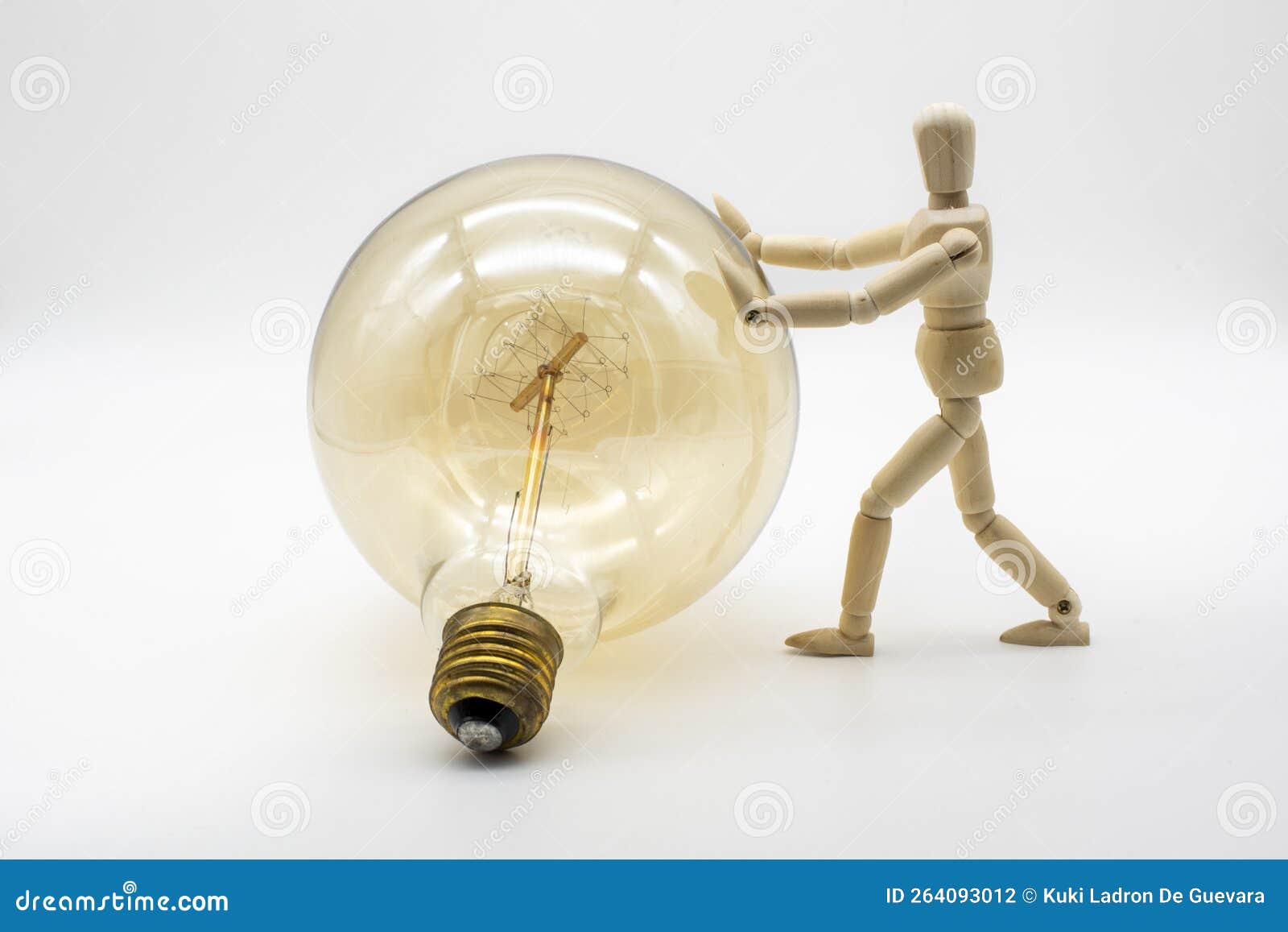 wooden mannequin pushing a electric light bulb