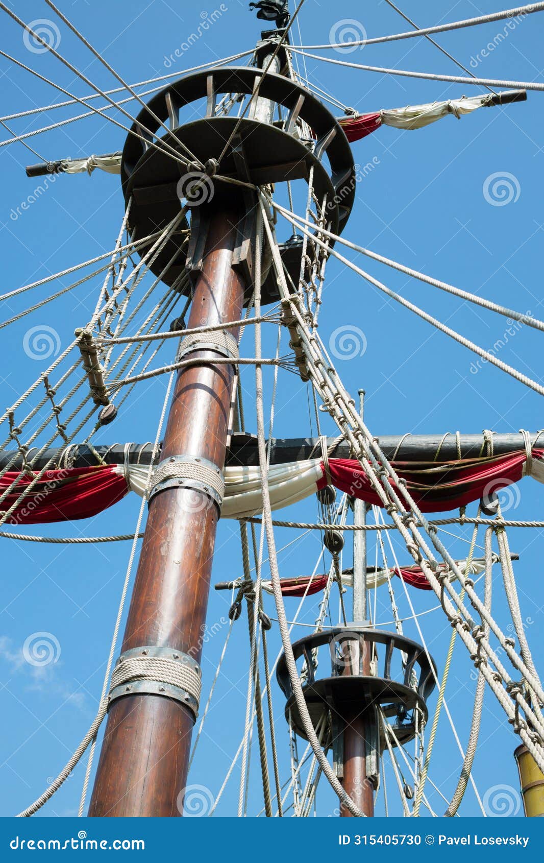 wooden mast of the ship with rope-ladder and