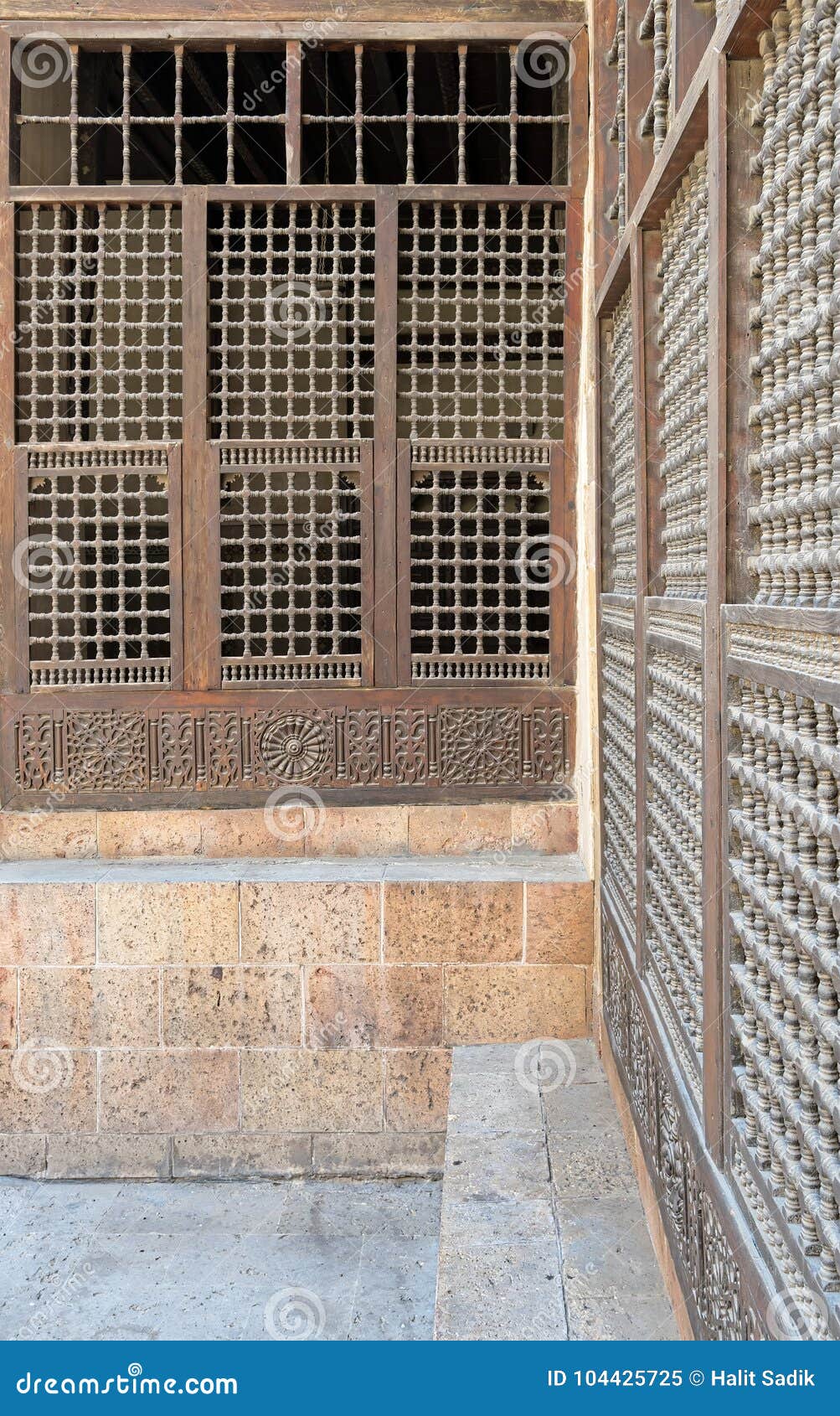 wooden ornate windows over stone brick wall