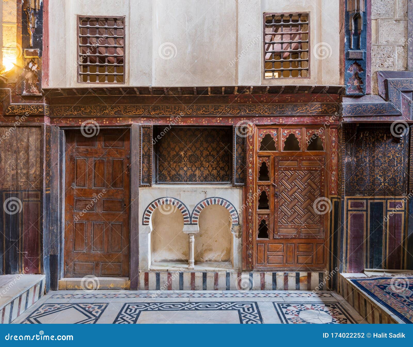 wooden painted floral patterns, arched niche, wooden door, decorated cupboard, and marble floor