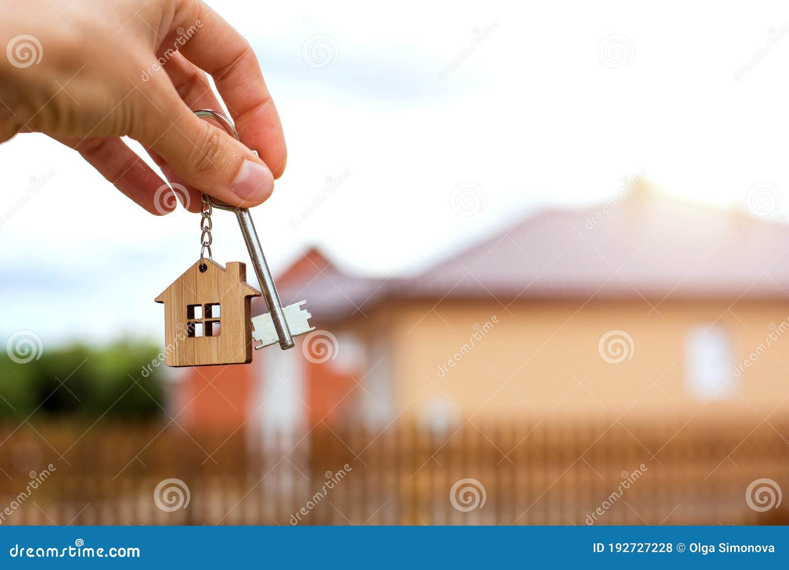wooden pendant of a house and key. background of fence and cottage. dream of home, building, , delivery of the project, movi