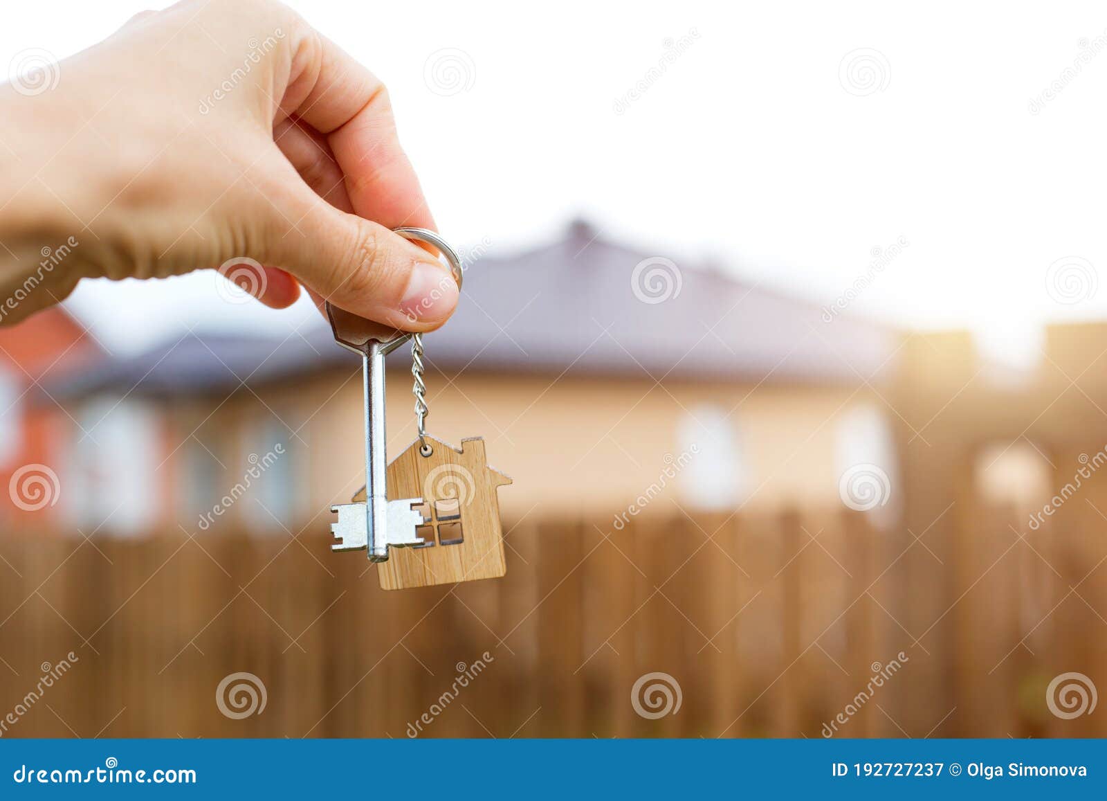 wooden pendant of a house and key. background of fence and cottage. dream of home, building, , delivery of the project, movi