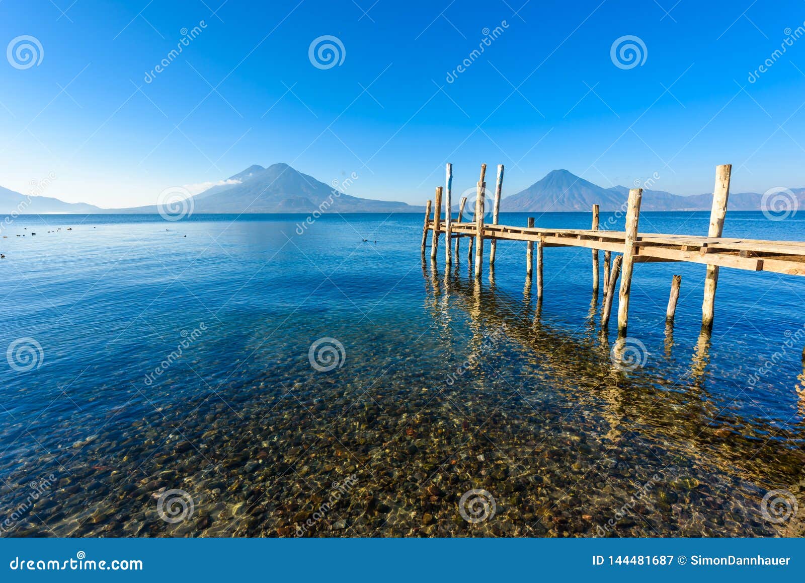 wooden pier at lake atitlan on the beach in panajachel, guatemala. with beautiful landscape scenery of volcanoes toliman, atitlan