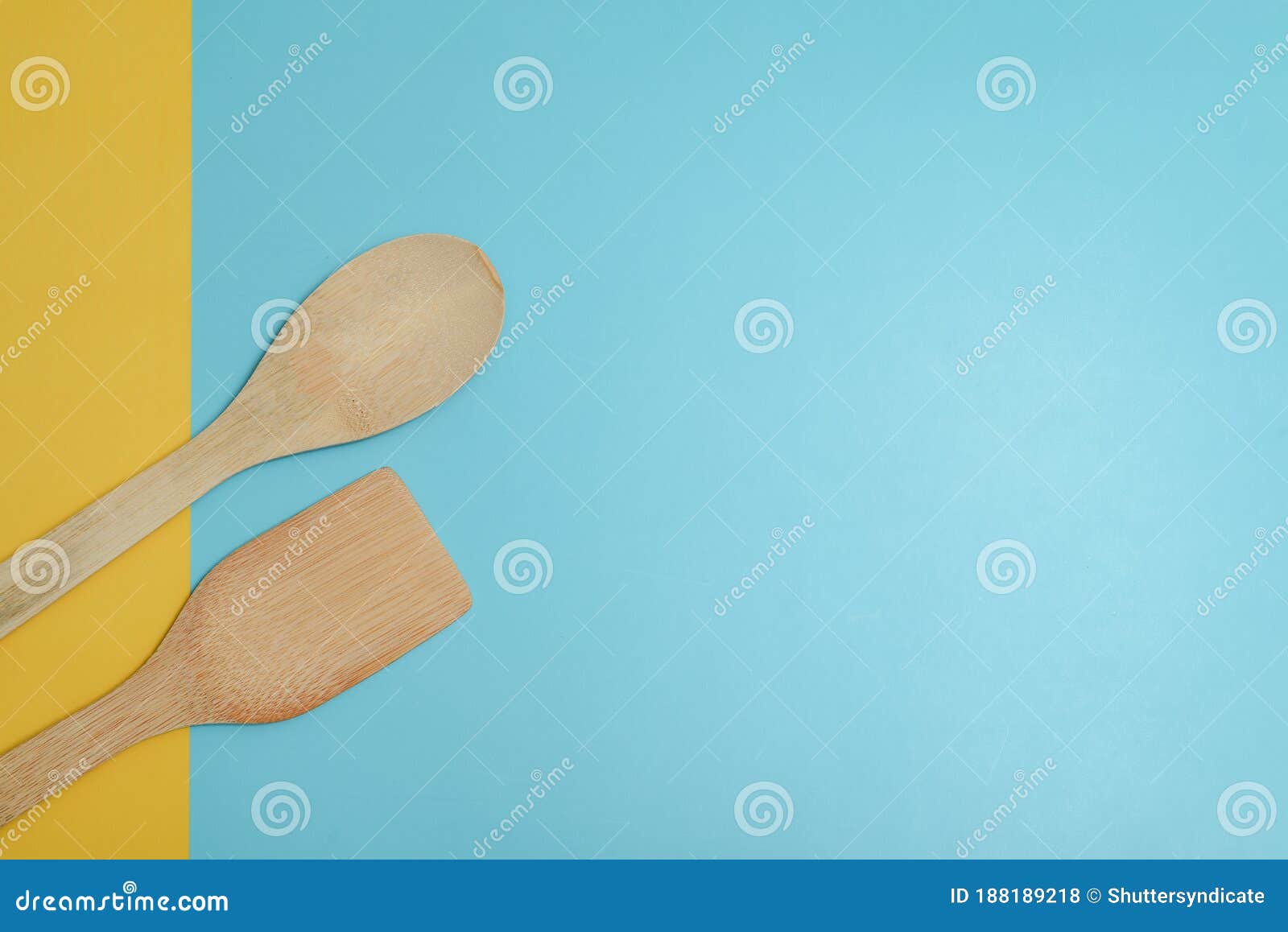 two wooden spatulas on cyan surface.