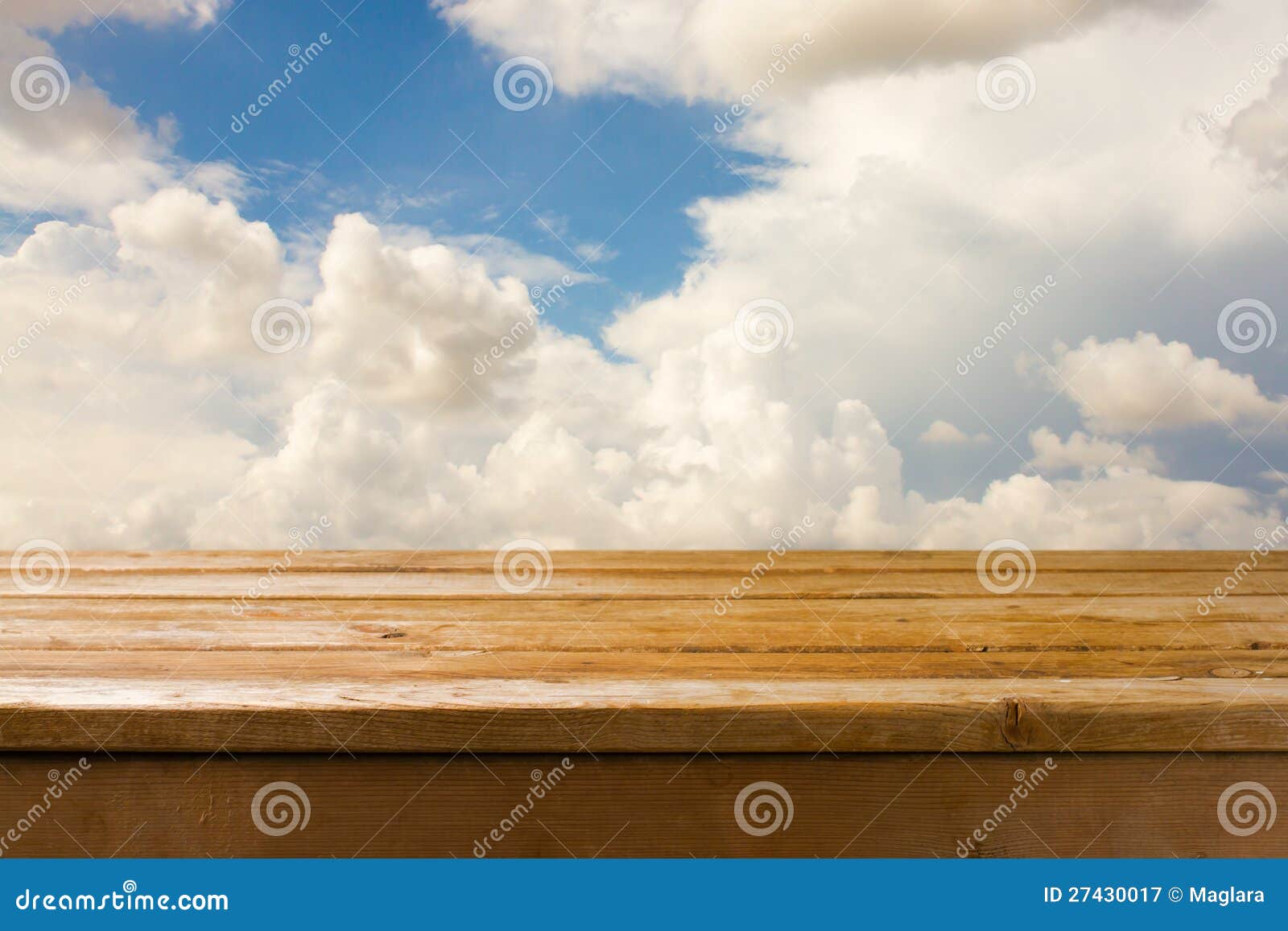 Wooden table and blue sky. Background with wooden table and blue cloudy sky