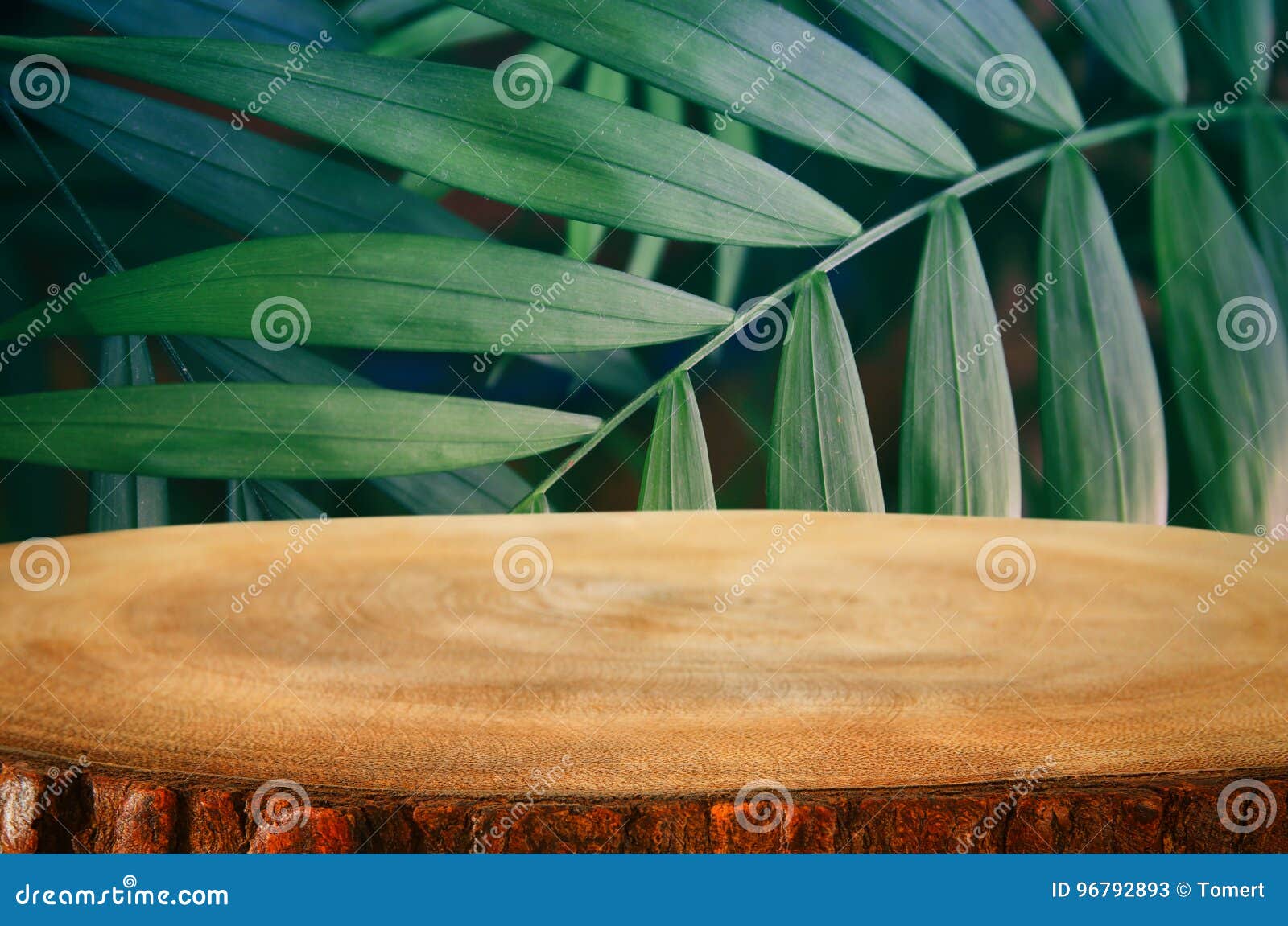 wooden table in front of tropical green floral background. for product display and presentation