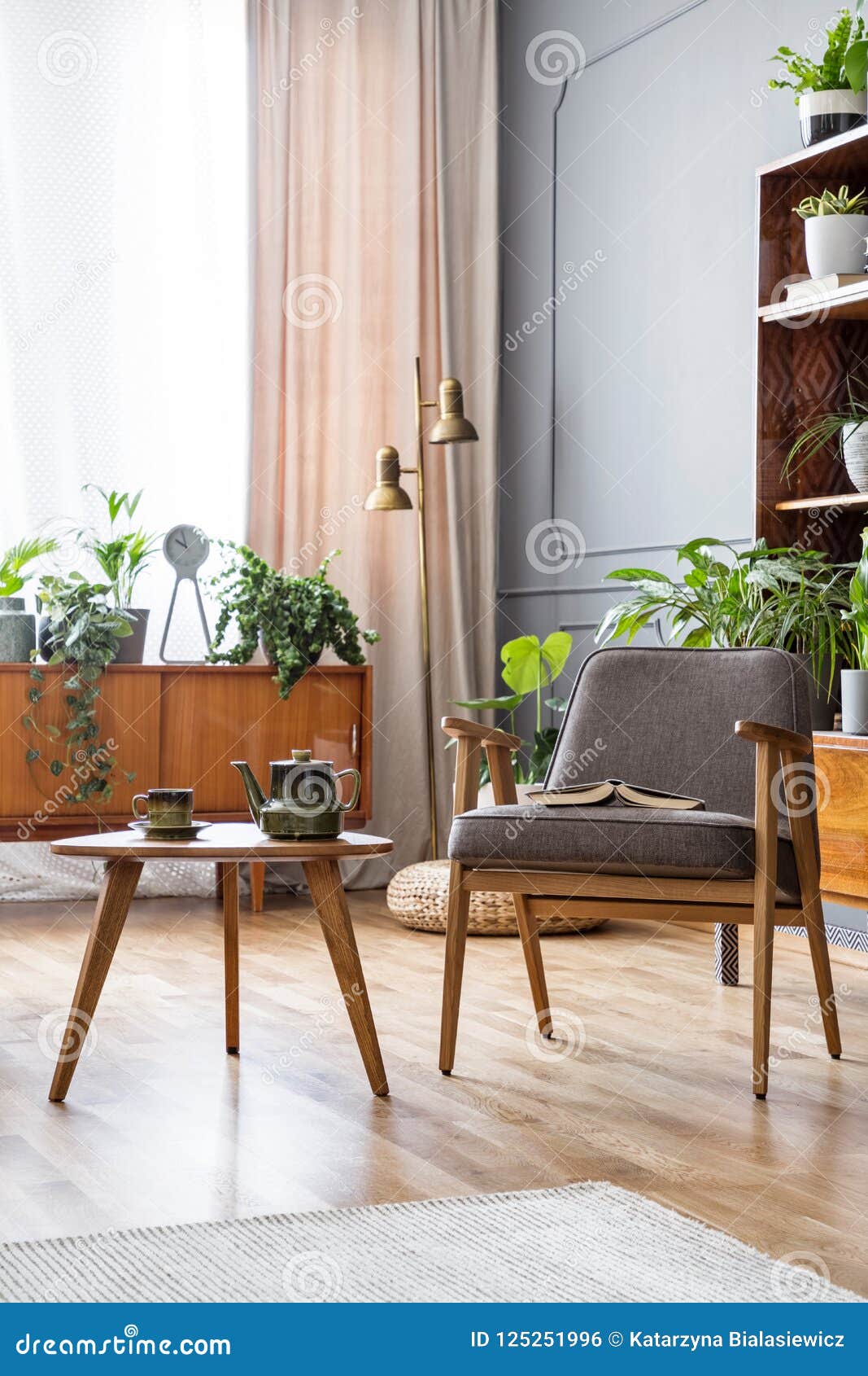 Wooden Table Next To Grey Armchair In Vintage Living Room 