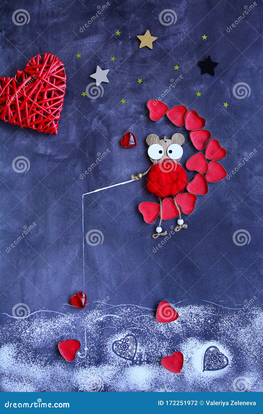 a wooden toy mouse sits on the moon of red hearts and catches hearts in the river with a fishing rod on the background of multi-