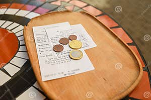 Wooden Tray In A Cafe With A Bill For Payment And Change In Euro Coins 