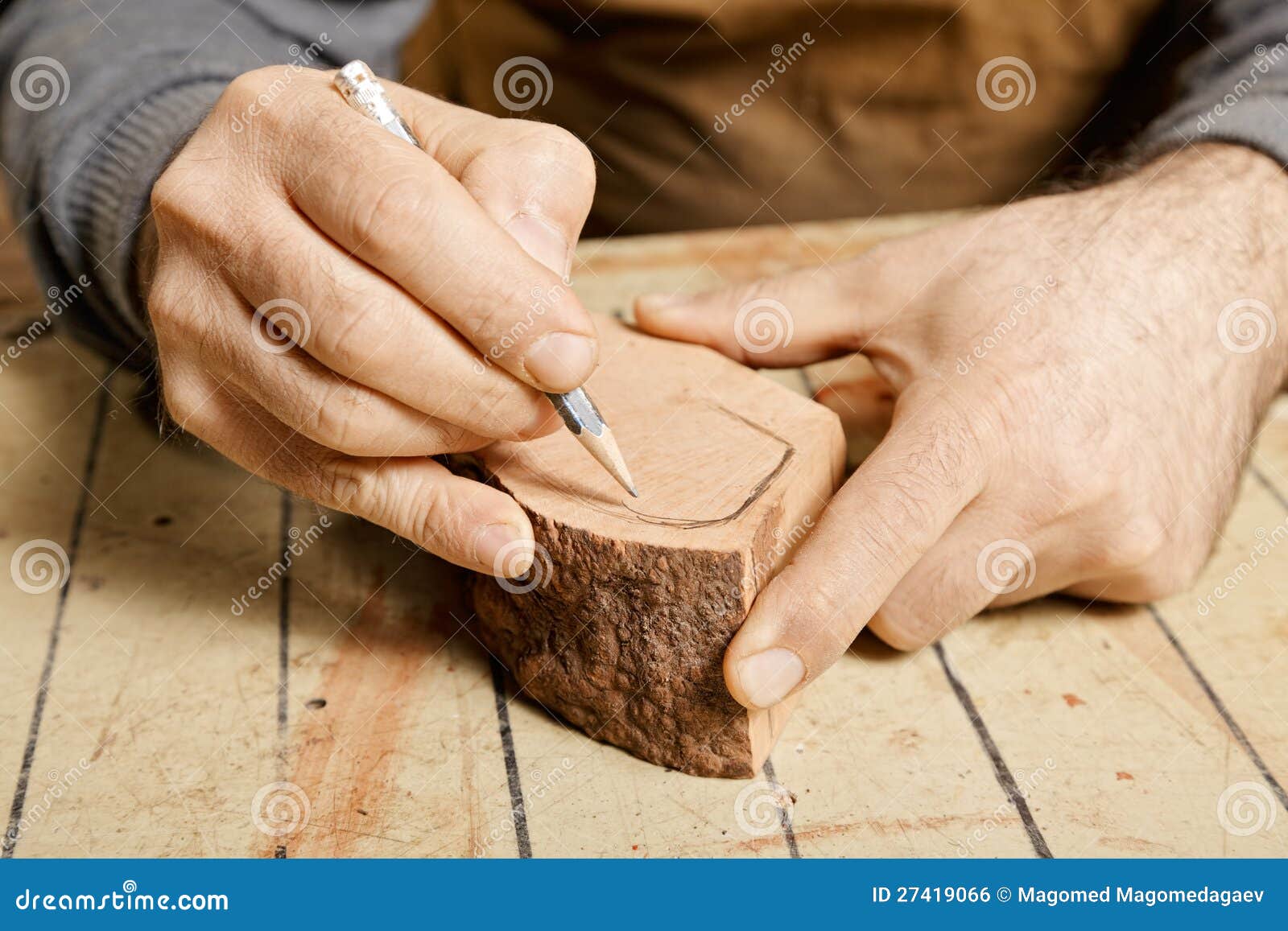 woodworker hands sketching on wood billet