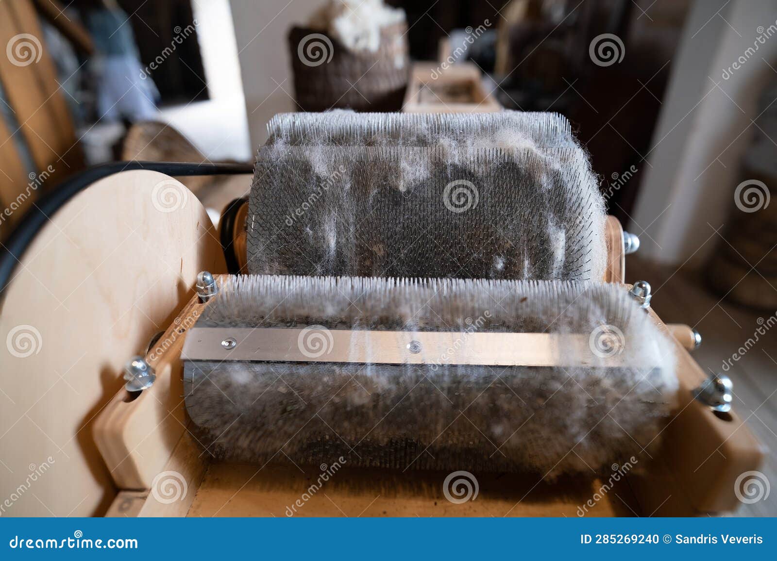 wool felting. the step of combing the material in a special carding machine. focus on the background