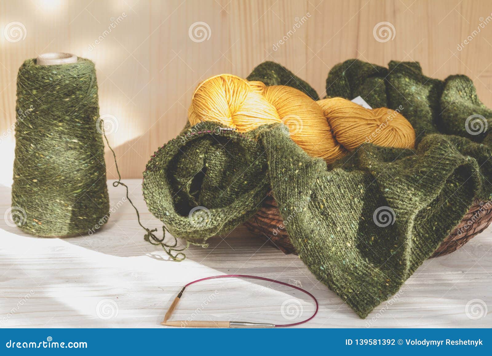 Wool Green and Yellow Yarn in Coils with Knitting Needles in Wicker ...