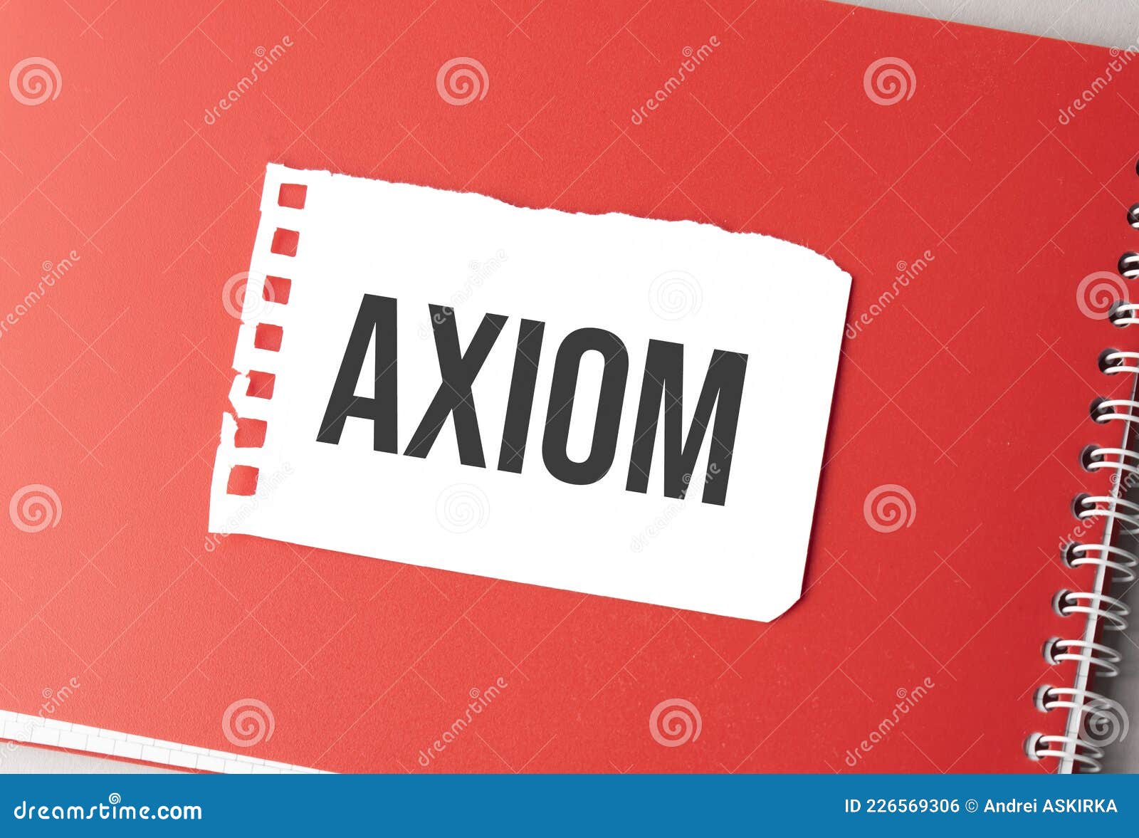 the word axiom on torn paper on red notepad