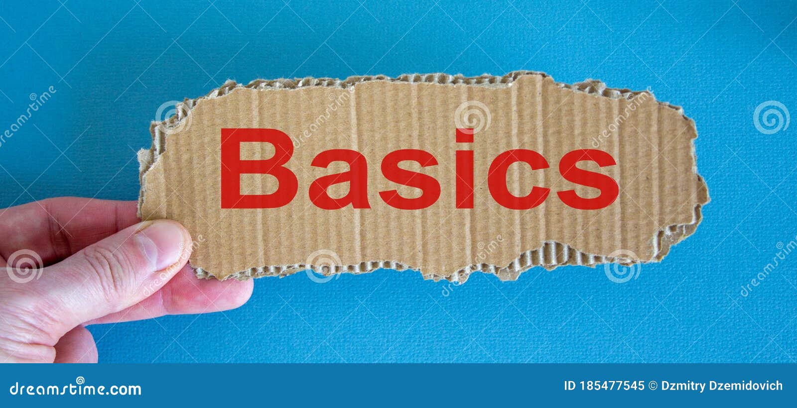 Word Basics on the Piece of Cardboard between Fingers Stock Image