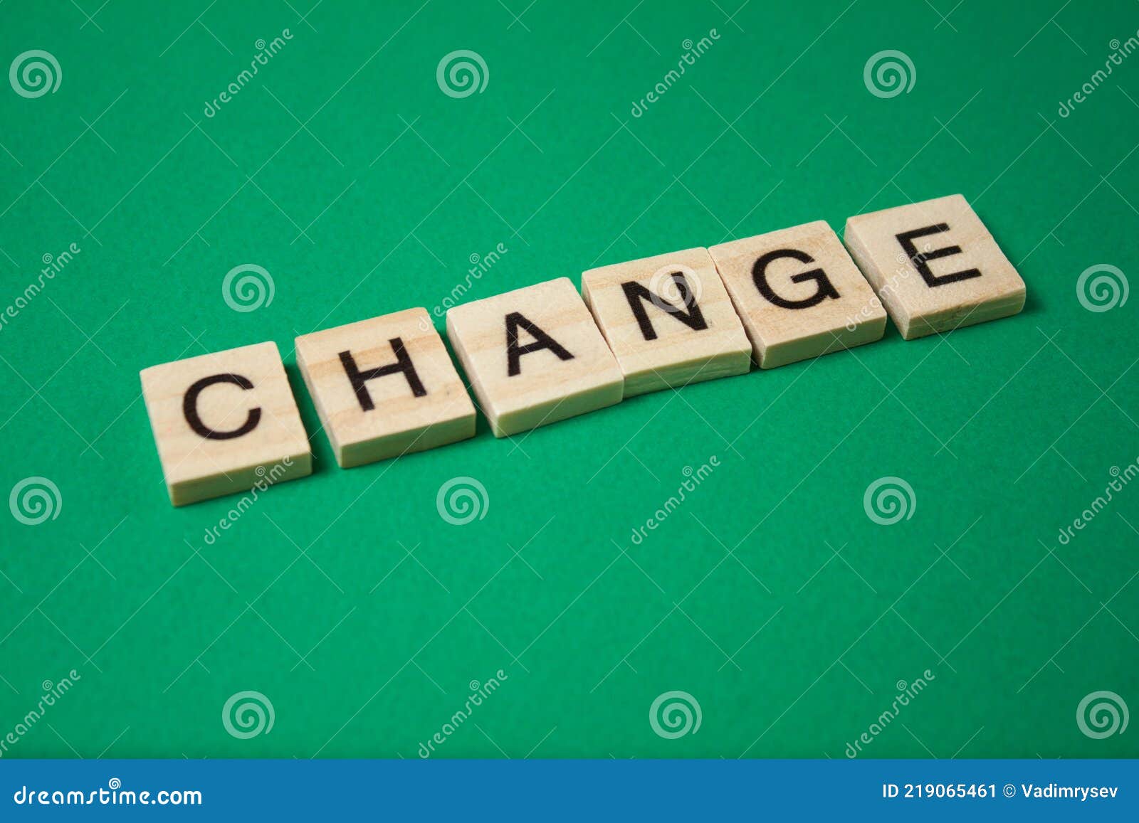 Word Change Made by Wooden Blocks on Green Background Stock Image