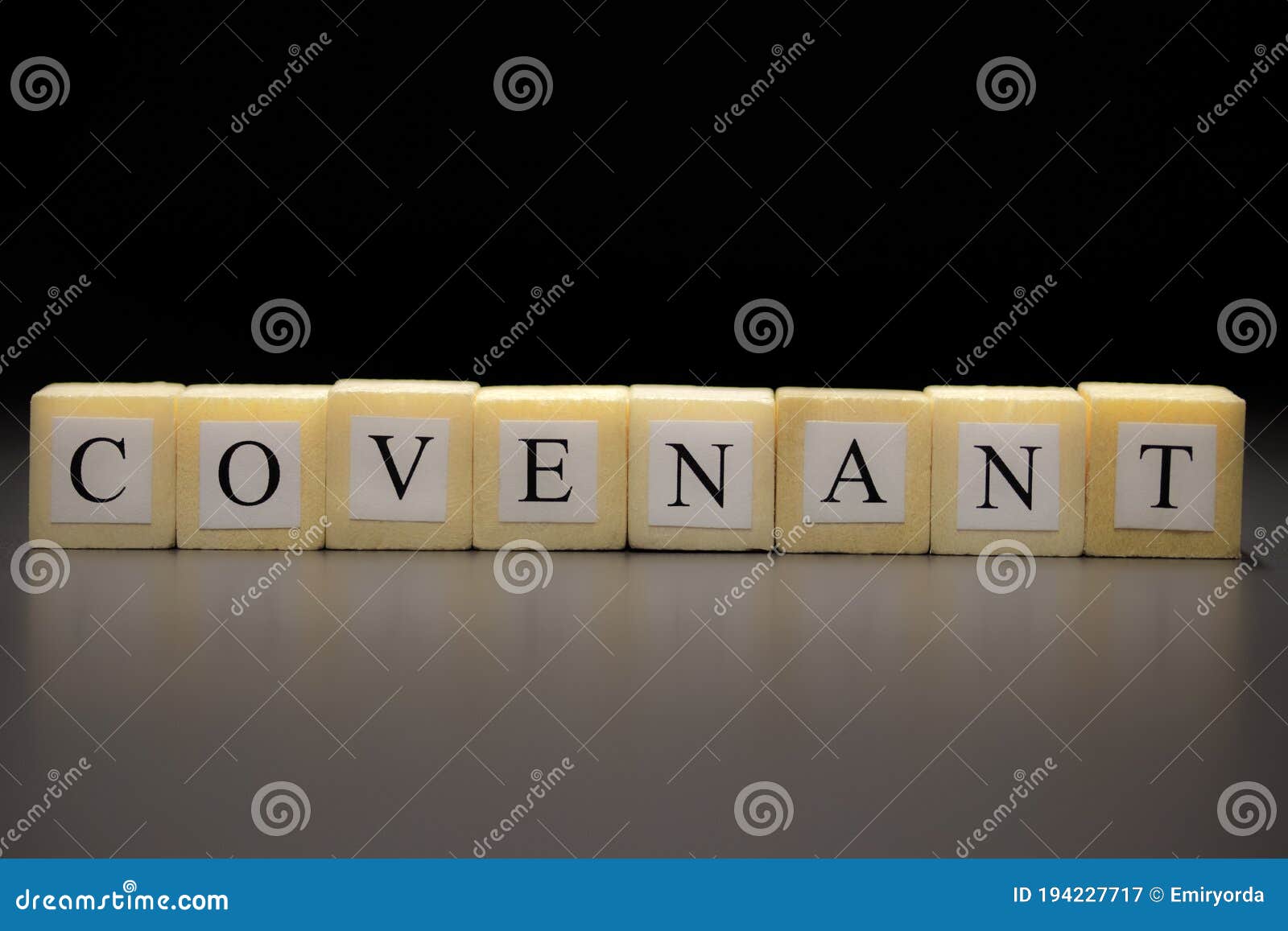 The word COVENANT written on wooden cubes isolated on a black background...