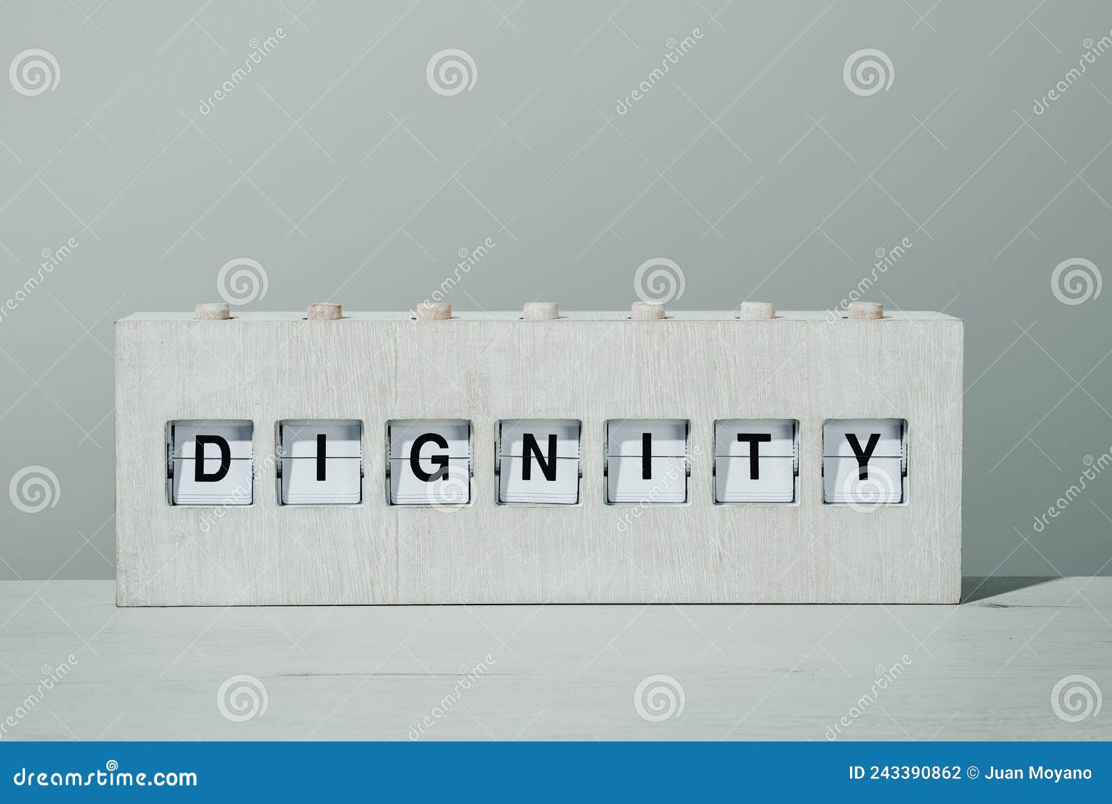 word dignity in a wooden split flap board