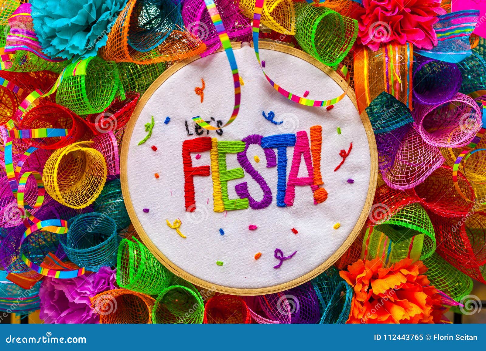 the word `fiesta` stitched in colorful letters on multicolored mash decorated with glitter and paper flowers