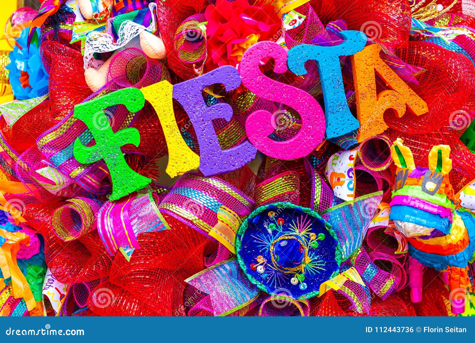 the word `fiesta` written in colorful foam letters on multicolored mash decorated with glitter and small sombrero