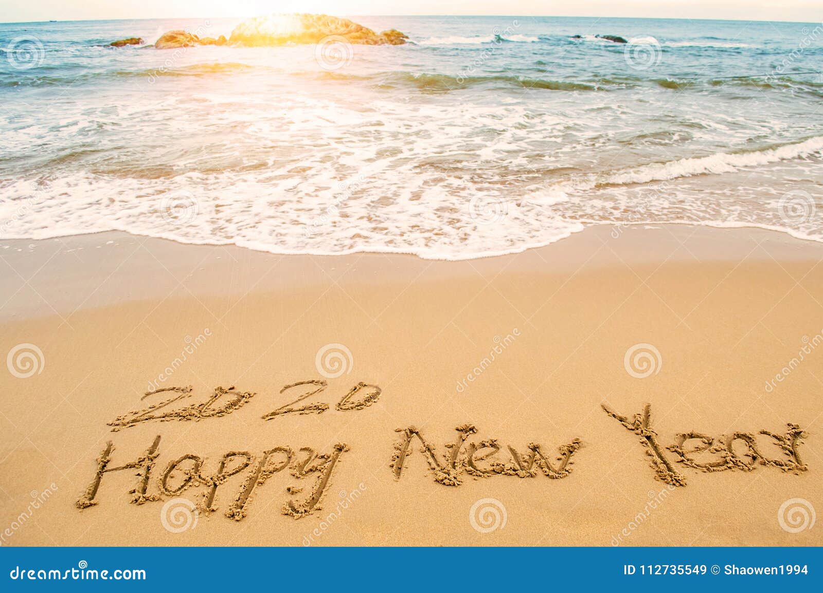 write 2020 happy new year on beach