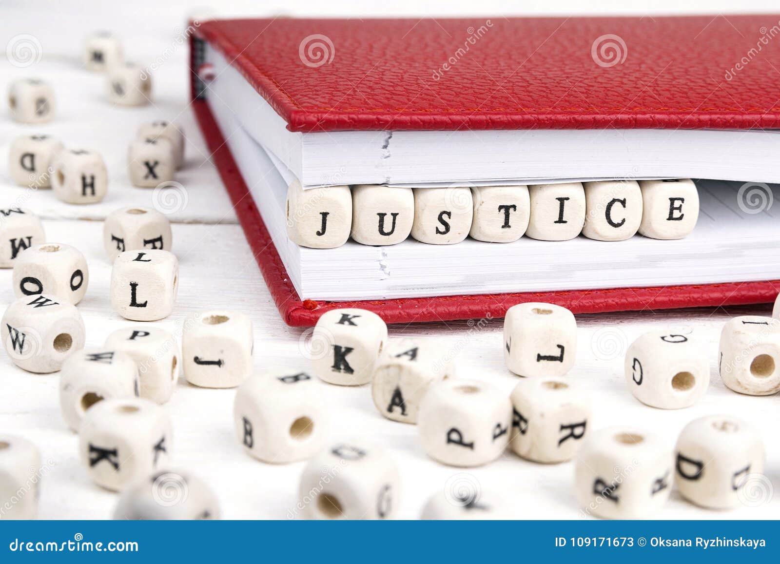 Word Justice Written in Wooden Blocks in Red Notebook on White W Stock