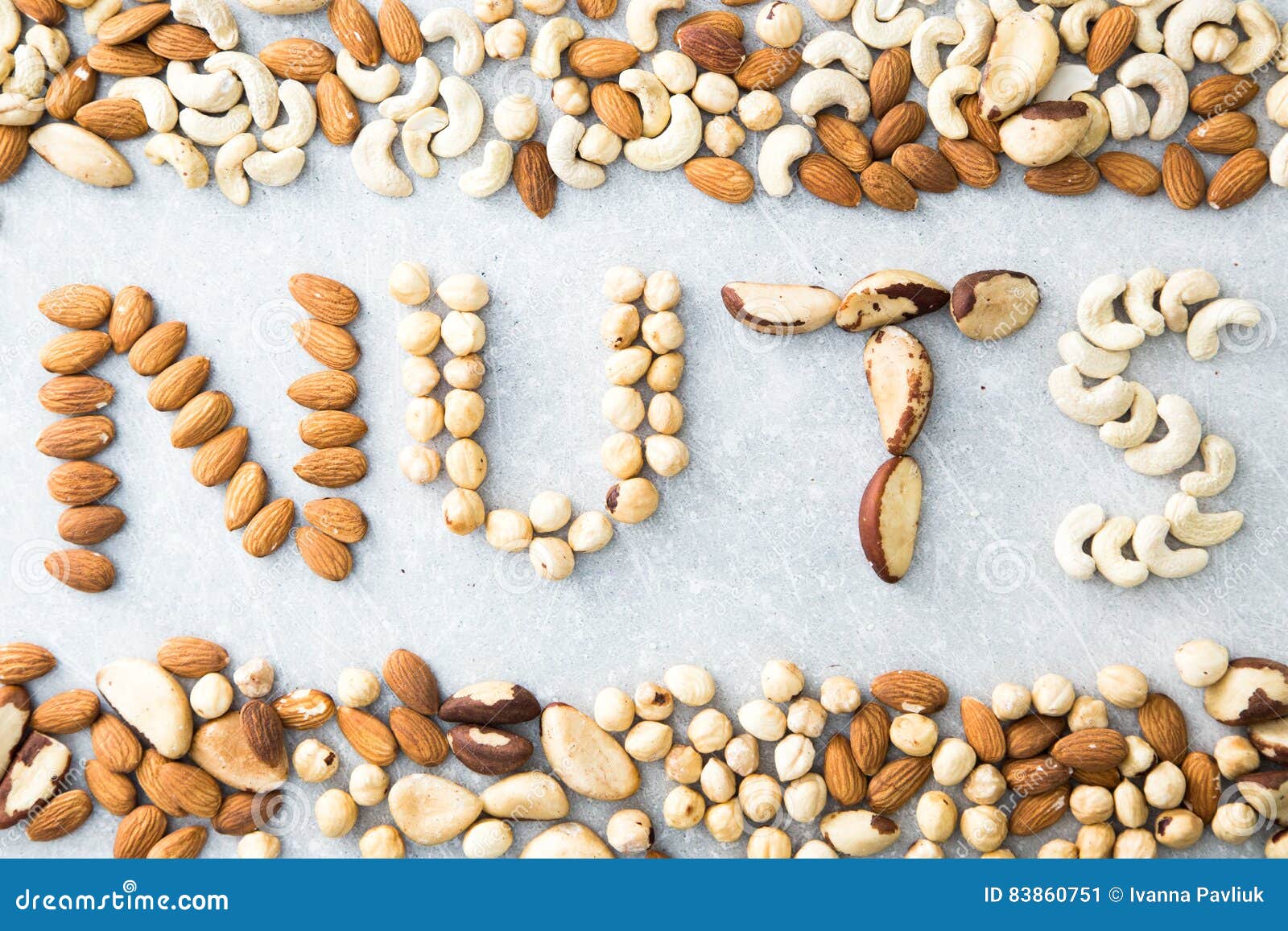 Word NUTS Spelled with Various Nuts on Stona Background. Assorted Mixed