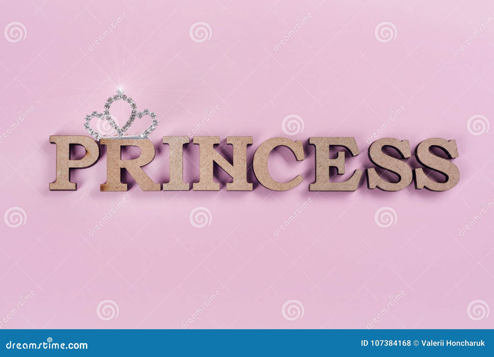 Word Princess abstract wooden letters Pink background with sparkling crown