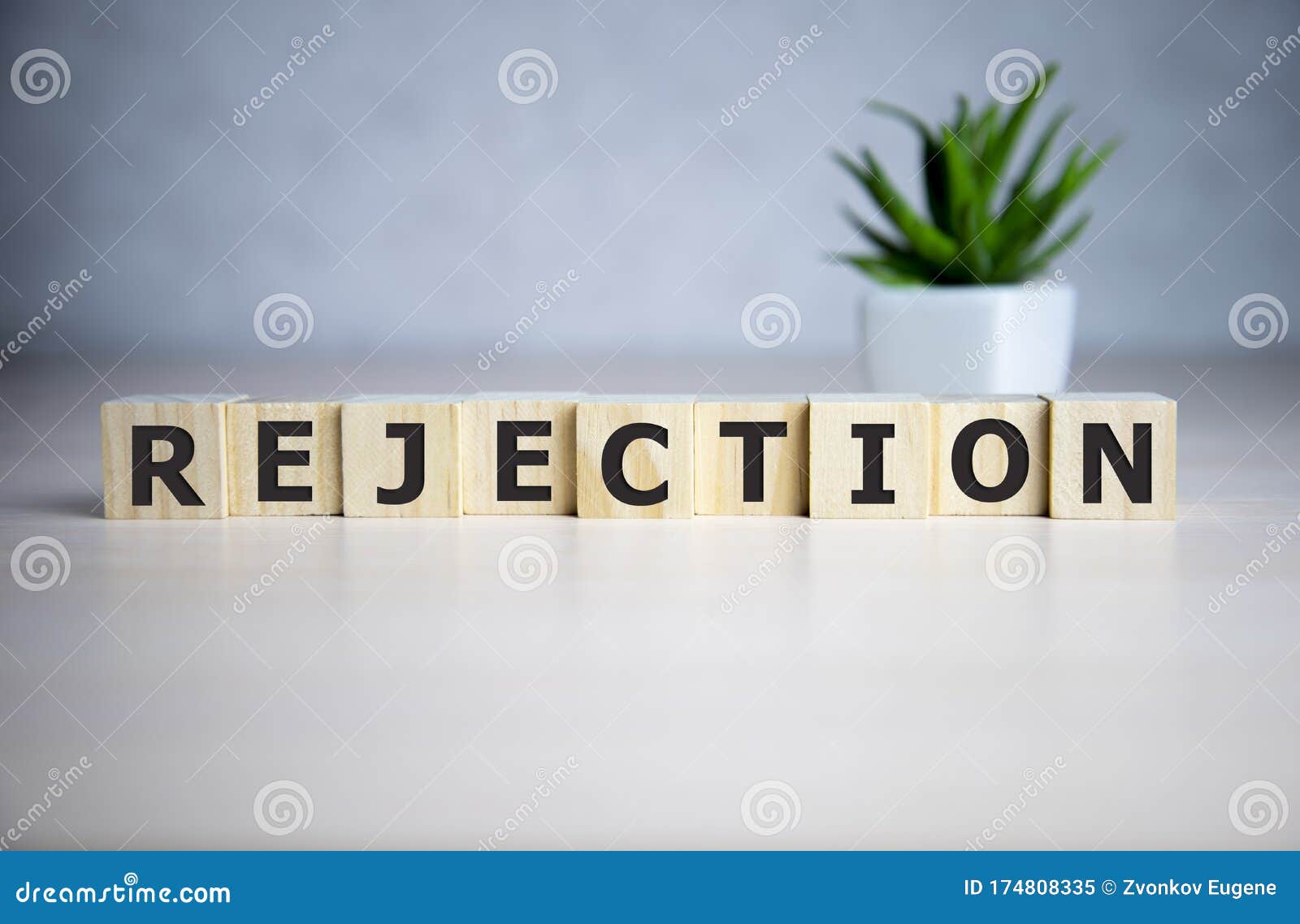 the word rejection, spelt with wooden letter tiles over a blue background
