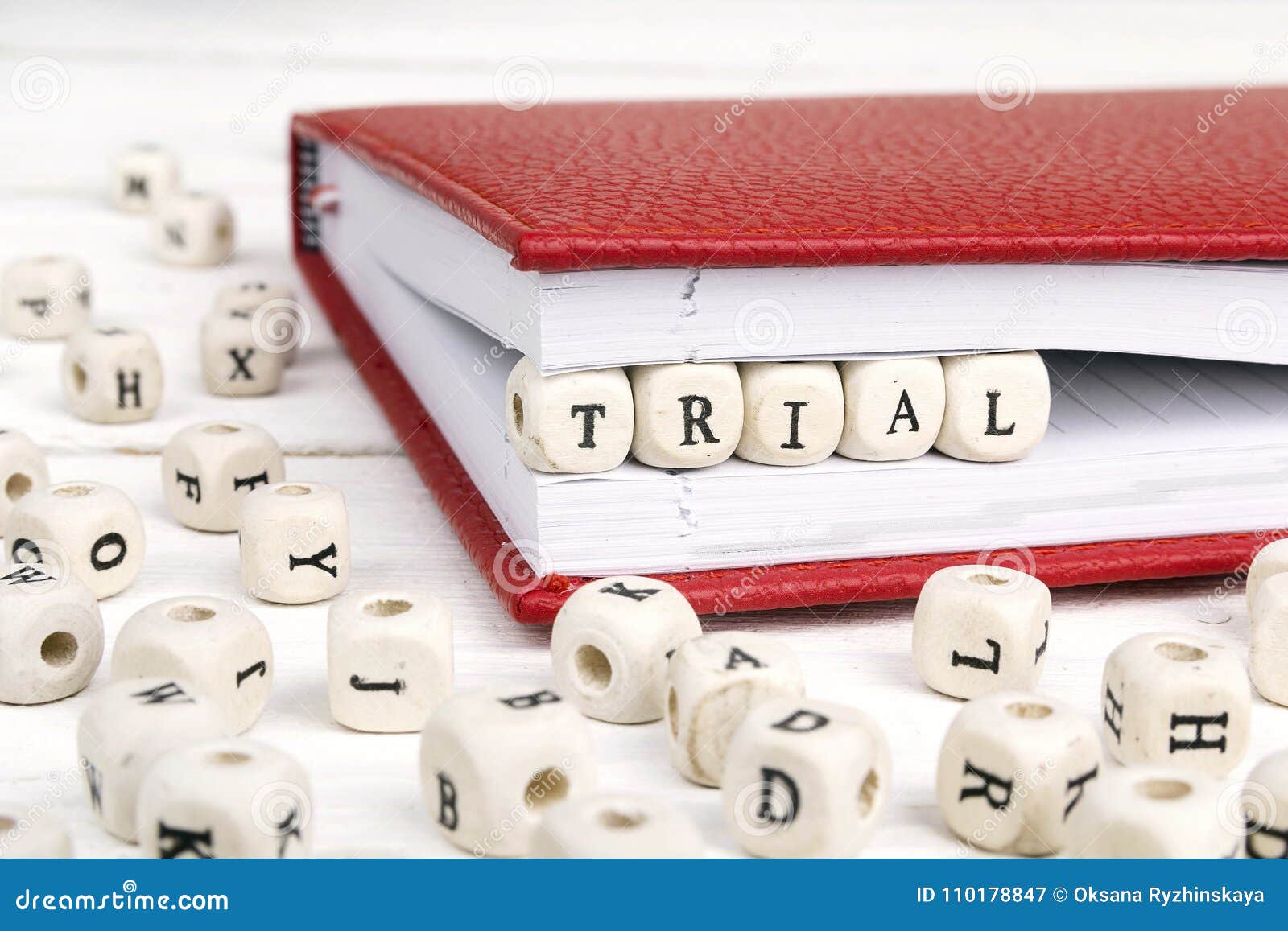 word trial written in wooden blocks in notebook on white wooden