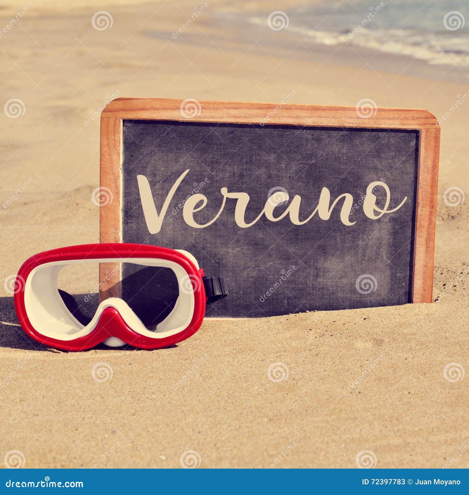 word verano, summer in spanish, in a chalkboard on the beach