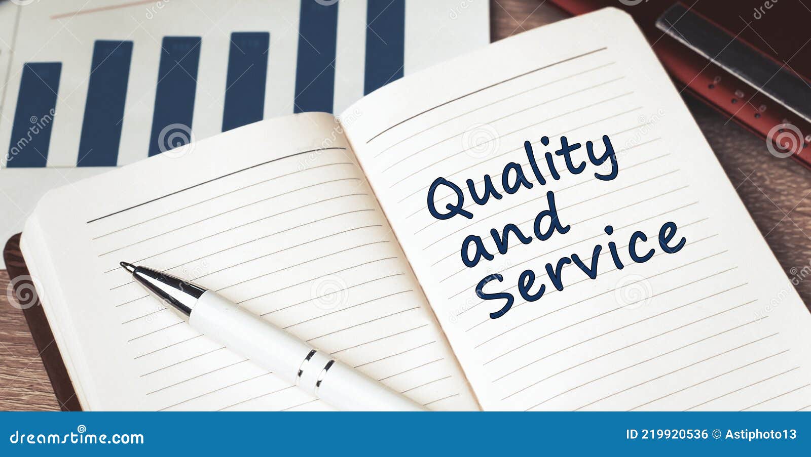 The Words Quality and Service Written on a White Notebook. Work and