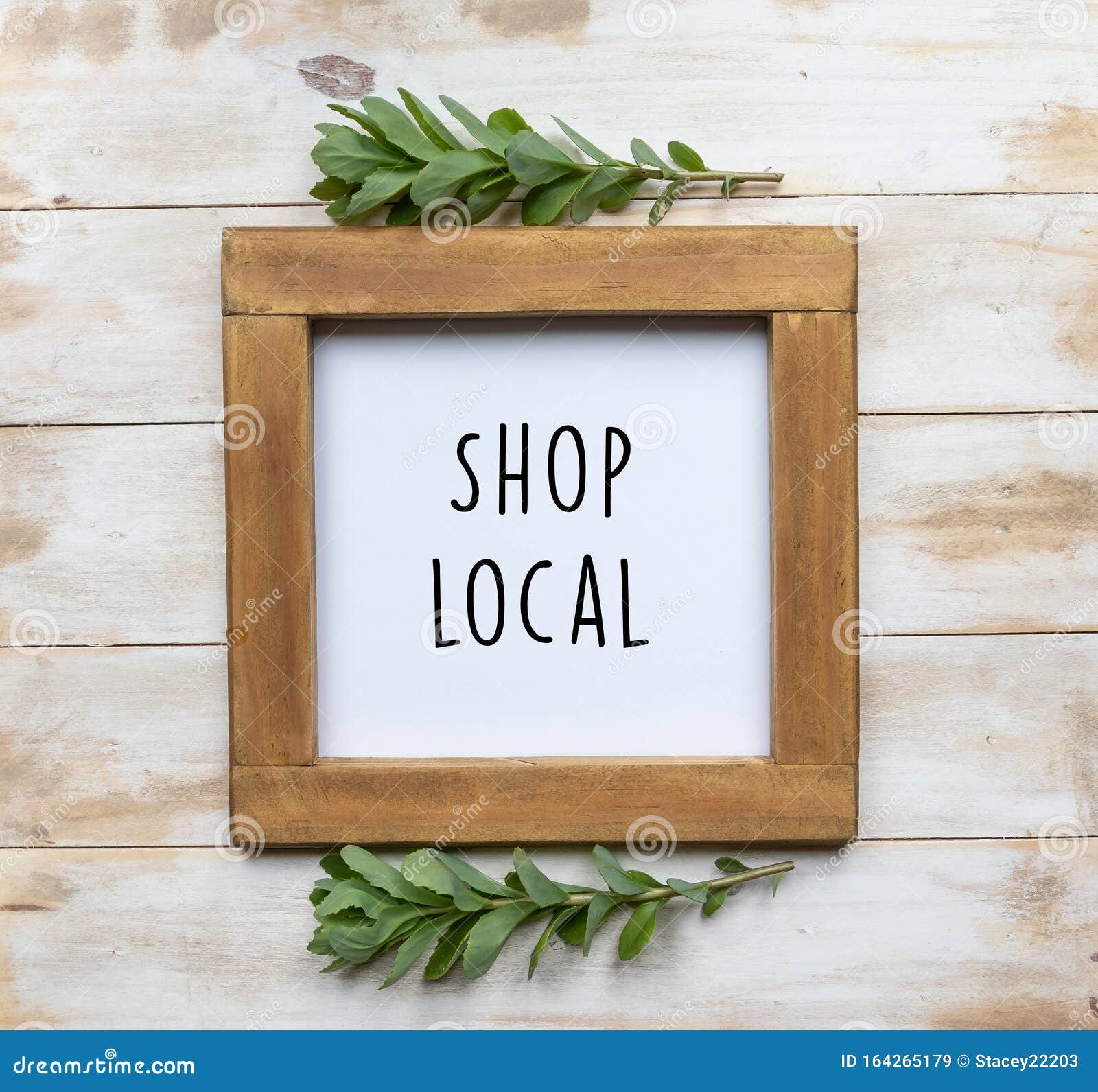 the words `shop local` in black text on a framed white board