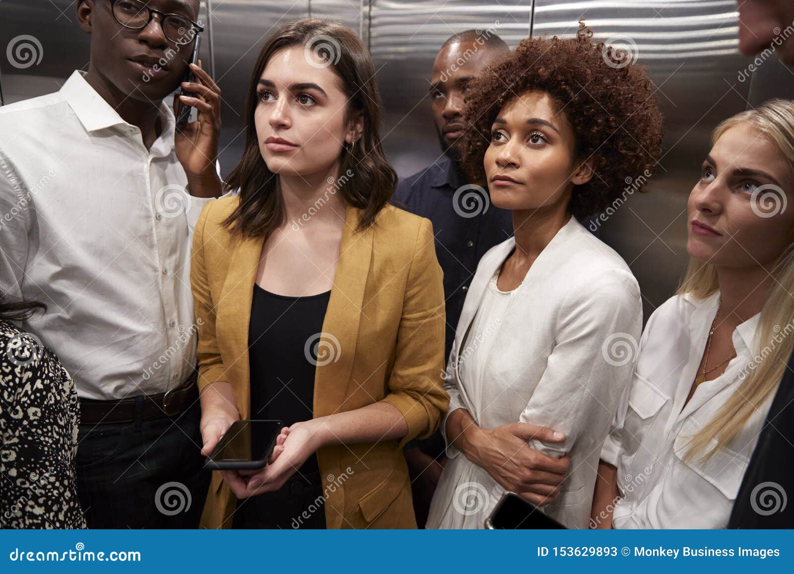 work colleagues standing in an elevator at their office, close up