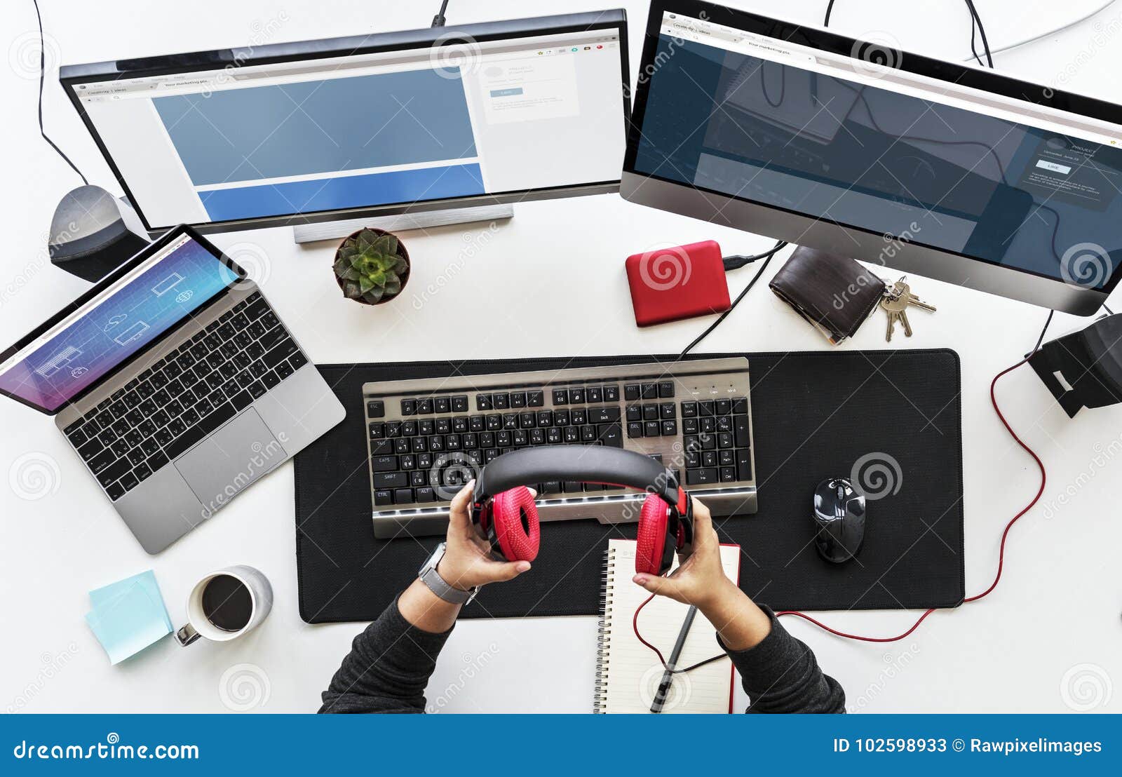 work desk with multiple screens and electronic devices.